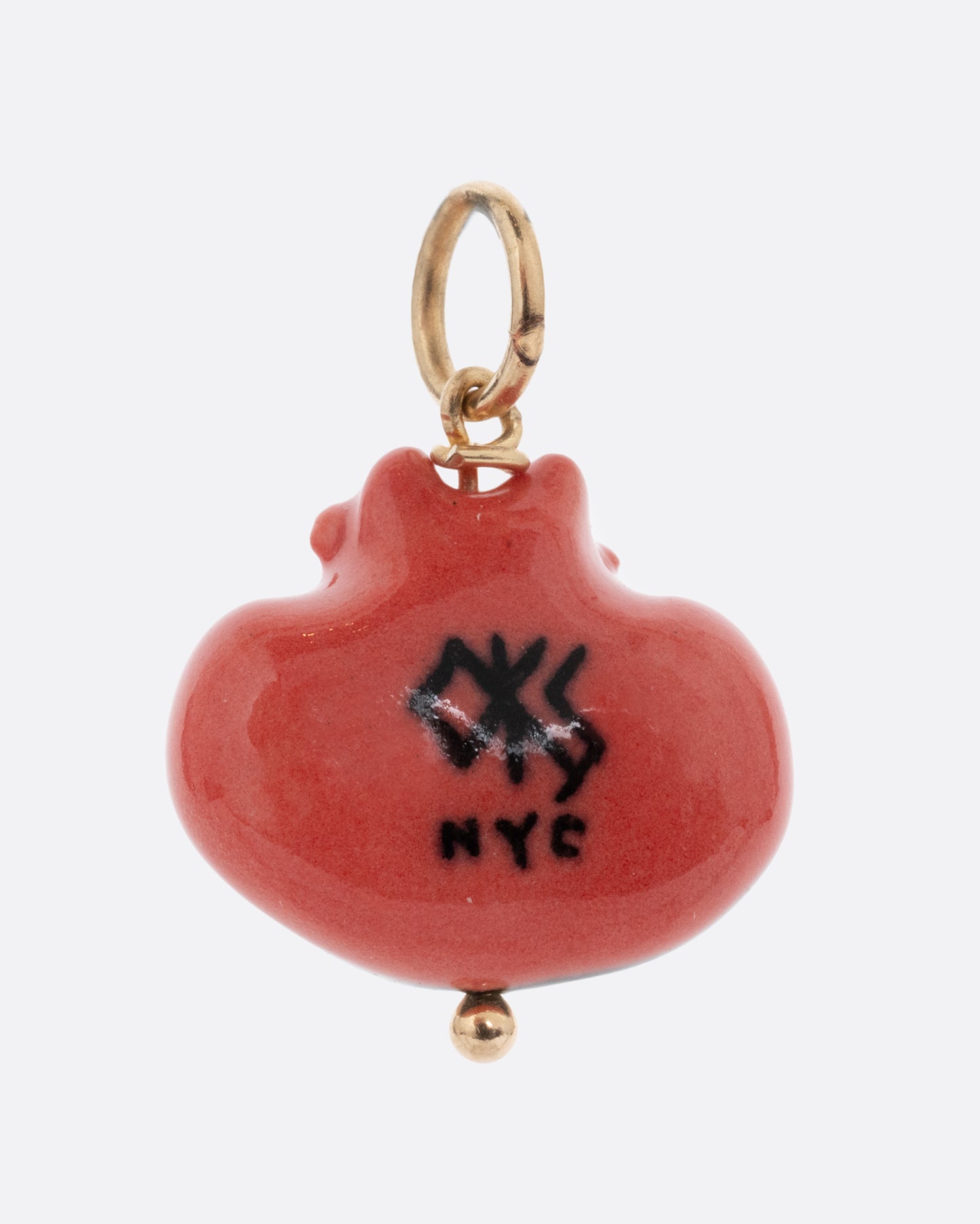 A porcelain cheshire cat charm with a yellow gold bail. Shown from the back.