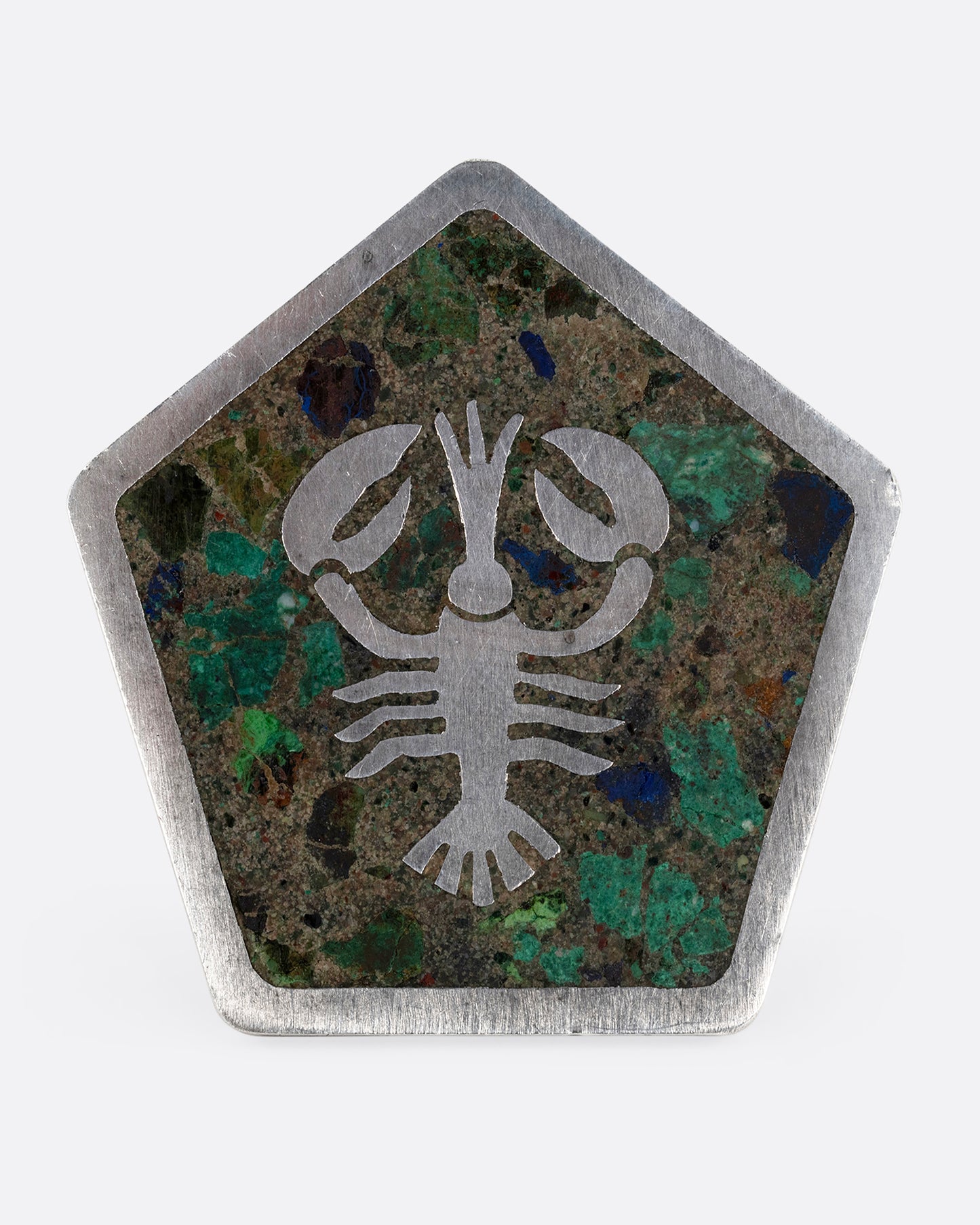 A silver pentagonal pin with a lobster set in malachite, turquoise, and lapis. Shown from the front.