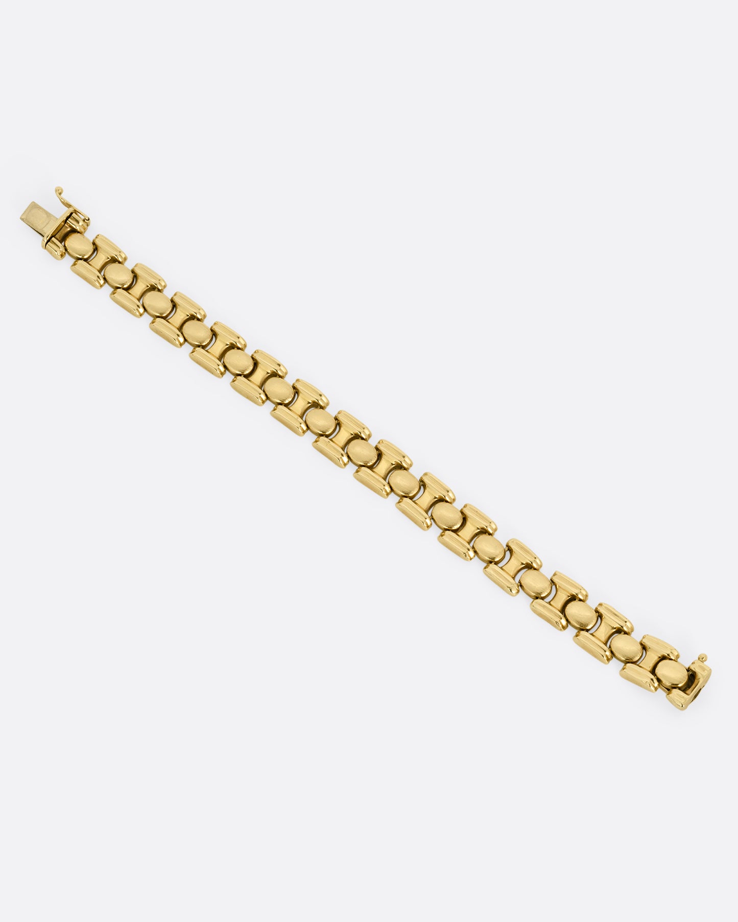 A yellow gold bracelet with repeating oval sections. Shown from the top open and lying flat.