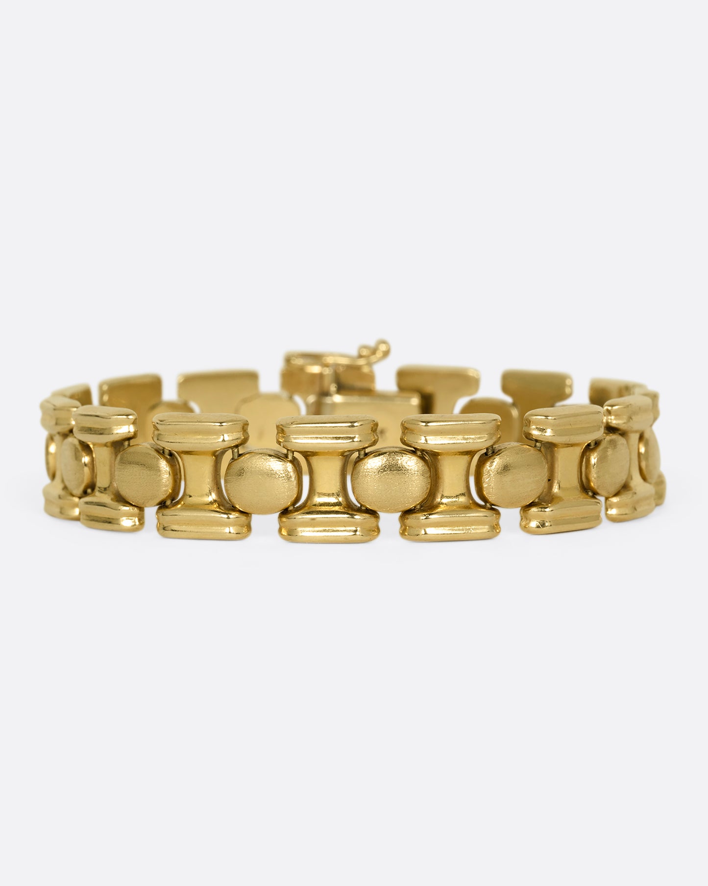 A yellow gold bracelet with repeating oval sections. Shown from the front.