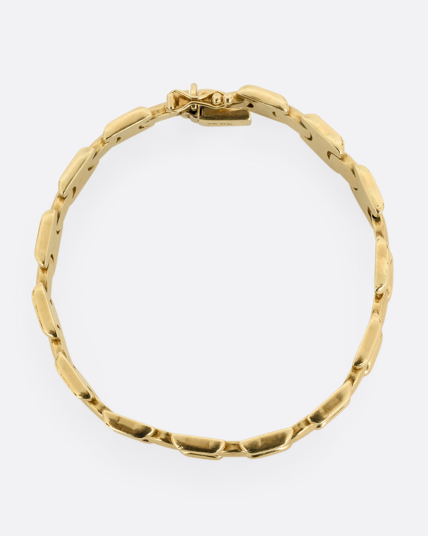 A yellow gold bracelet with repeating oval sections. Shown from the top.