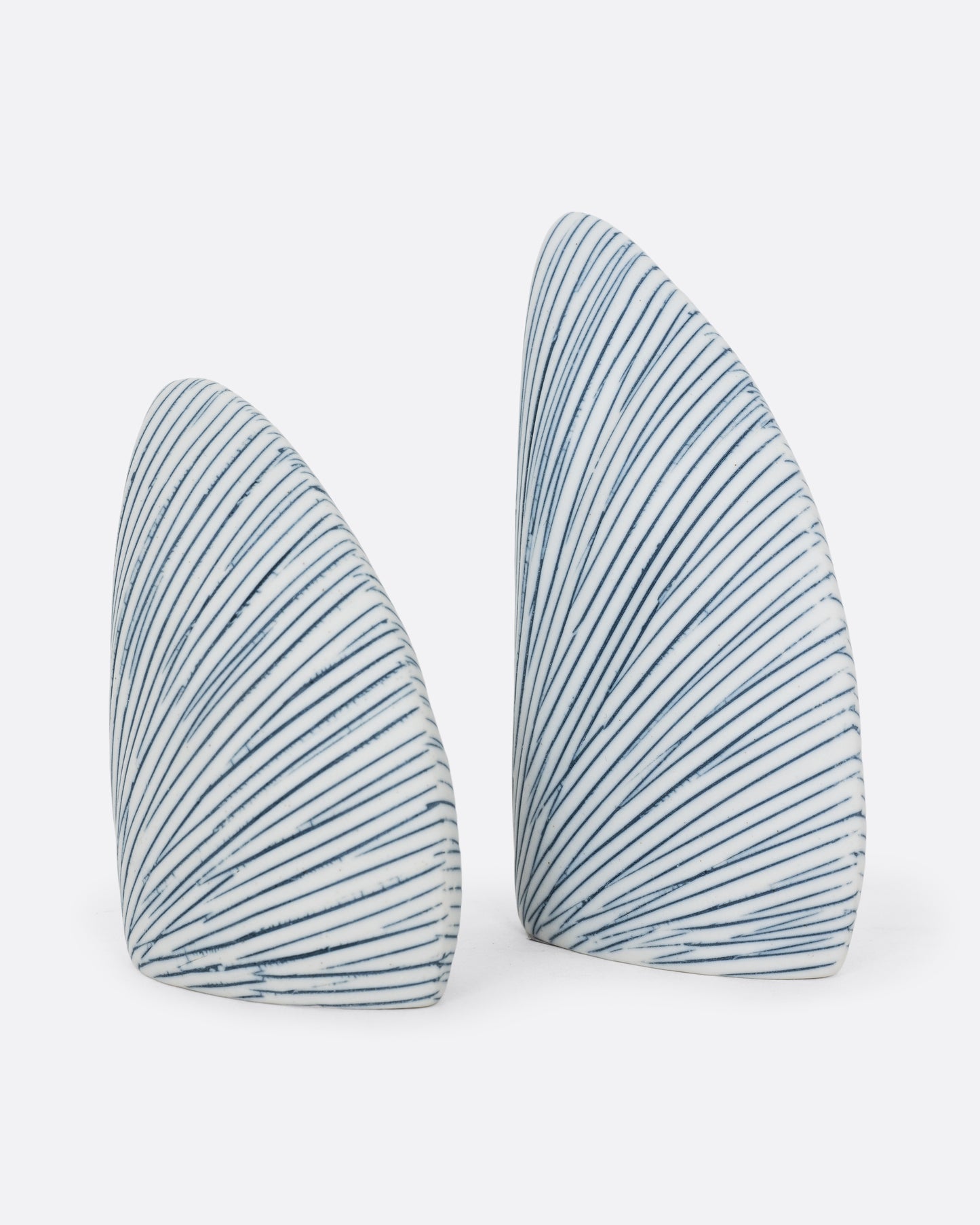 A pair of triangular white and blue striped pair of salt and pepper shakers. One shaker is shorter. Shown from the side.