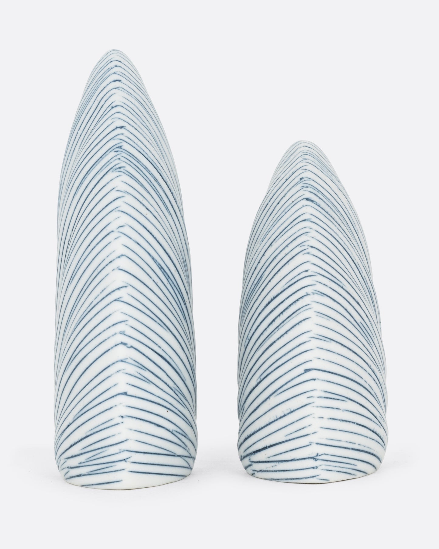 A pair of triangular white and blue striped pair of salt and pepper shakers. One shaker is shorter. Shown from the back.