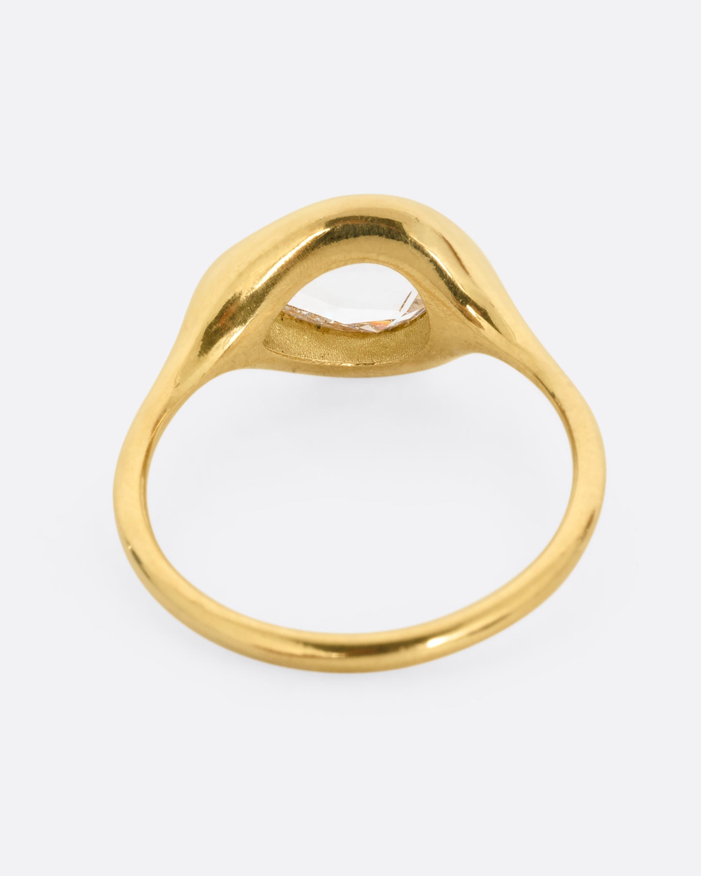 A yellow gold band with a rose cut pear shaped diamond. Shown from the back.