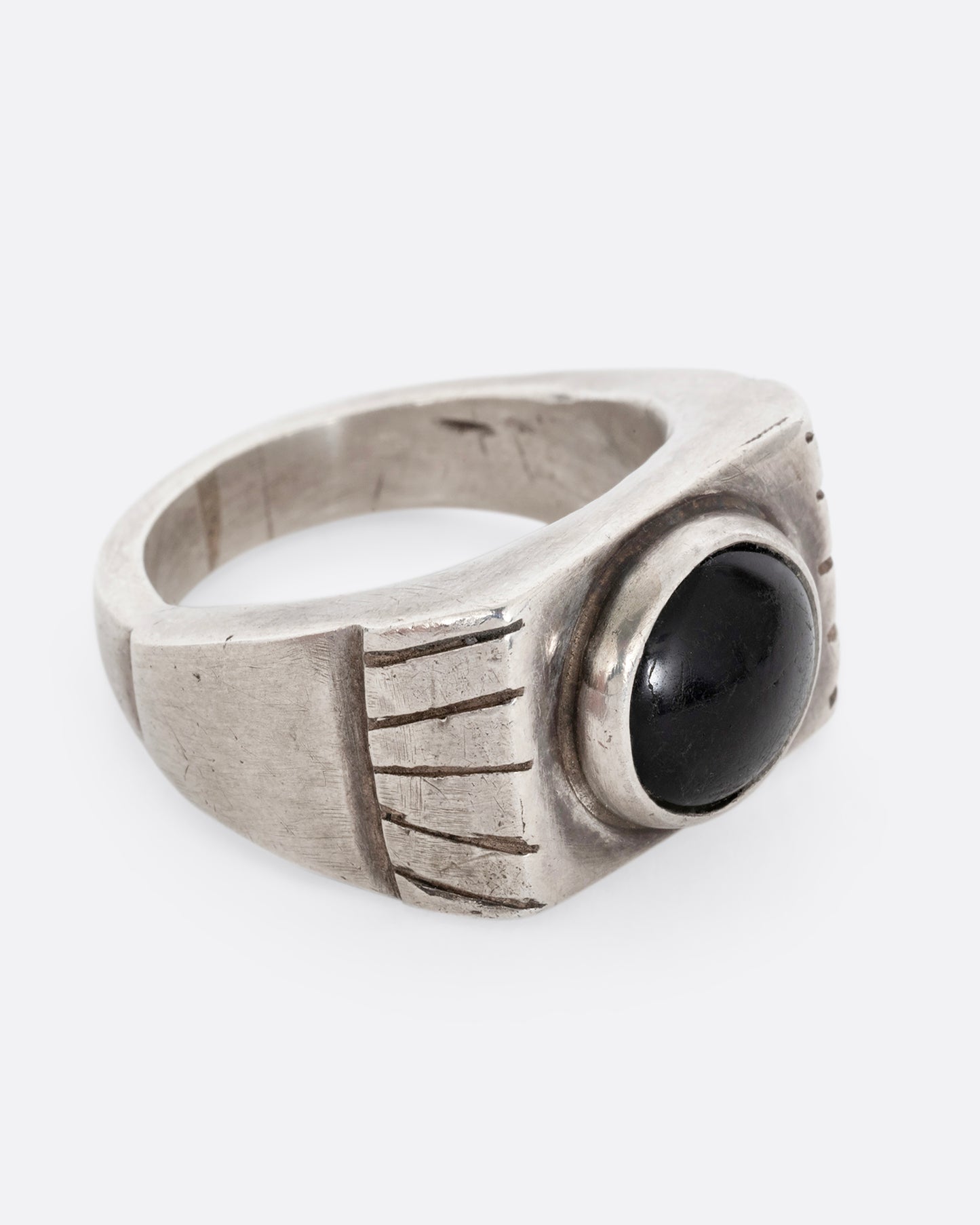 A silver ring with an oval onyx. Shown from the side.