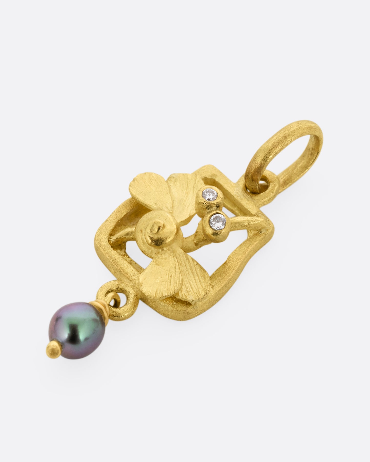 A yellow gold diamond eyed dragonfly charm with a keshi pearl. Shown from the lying flat.