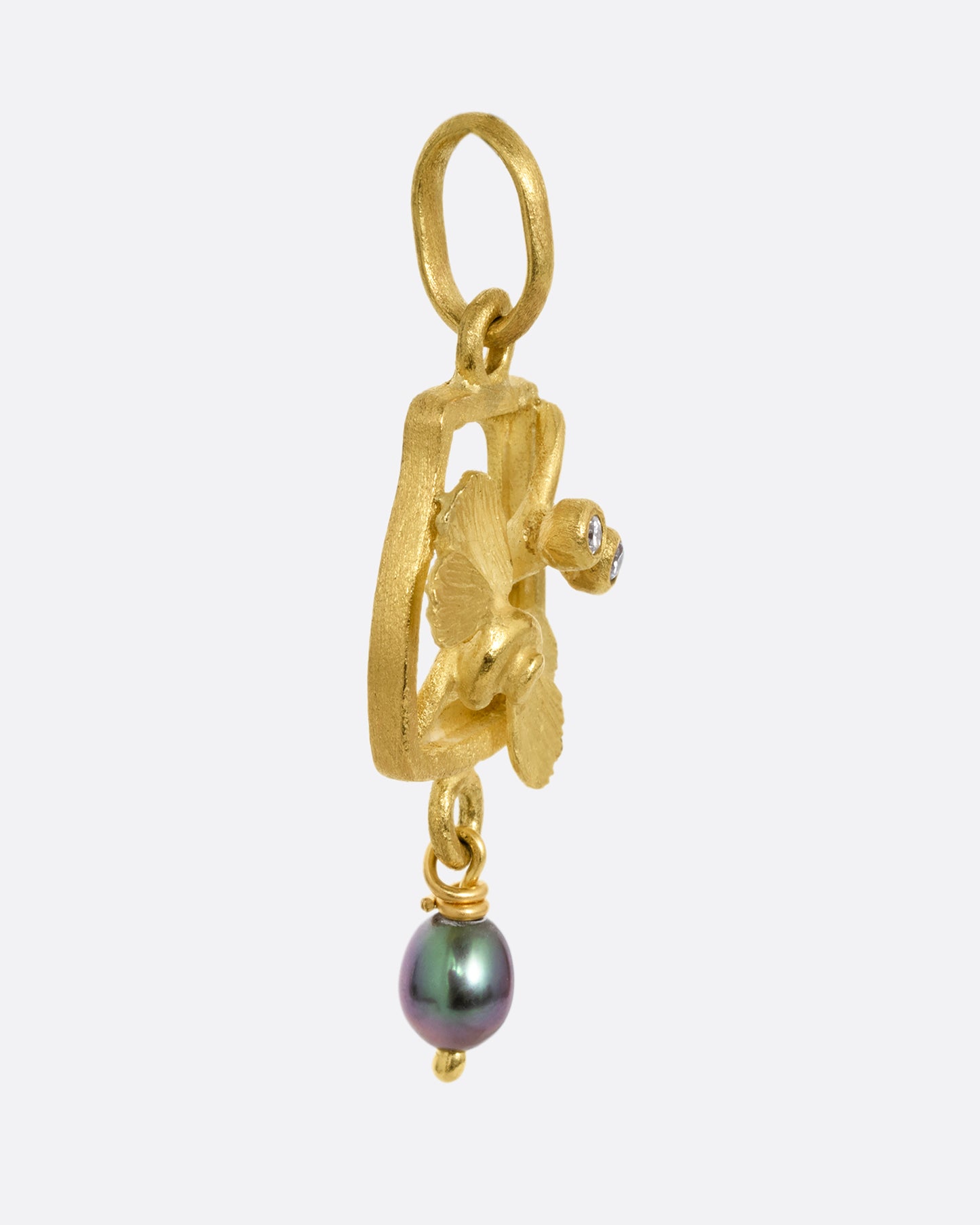 A yellow gold diamond eyed dragonfly charm with a keshi pearl. Shown from the side.