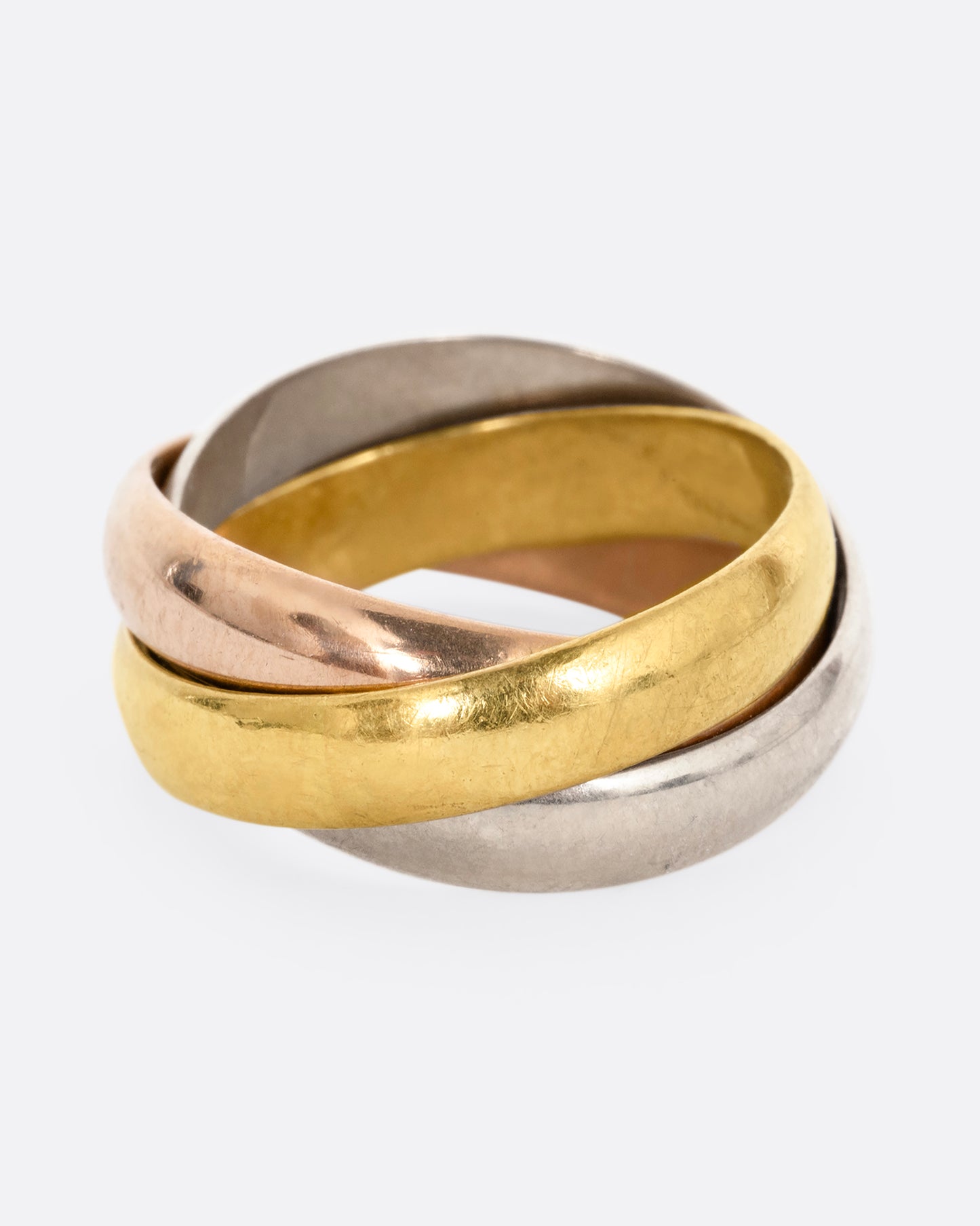 A ring with three interlocking bands in yellow, rose, and white gold, shown from the front.