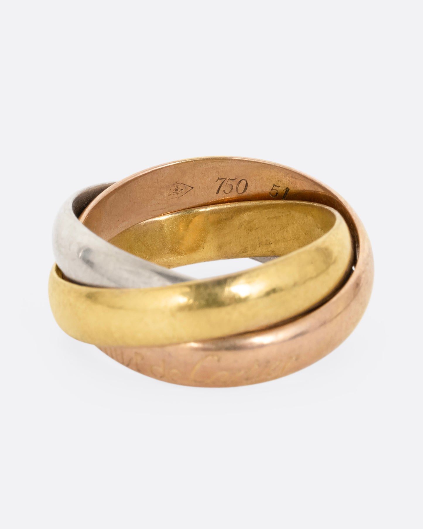 A ring with three interlocking bands in yellow, rose, and white gold, shown from the front.