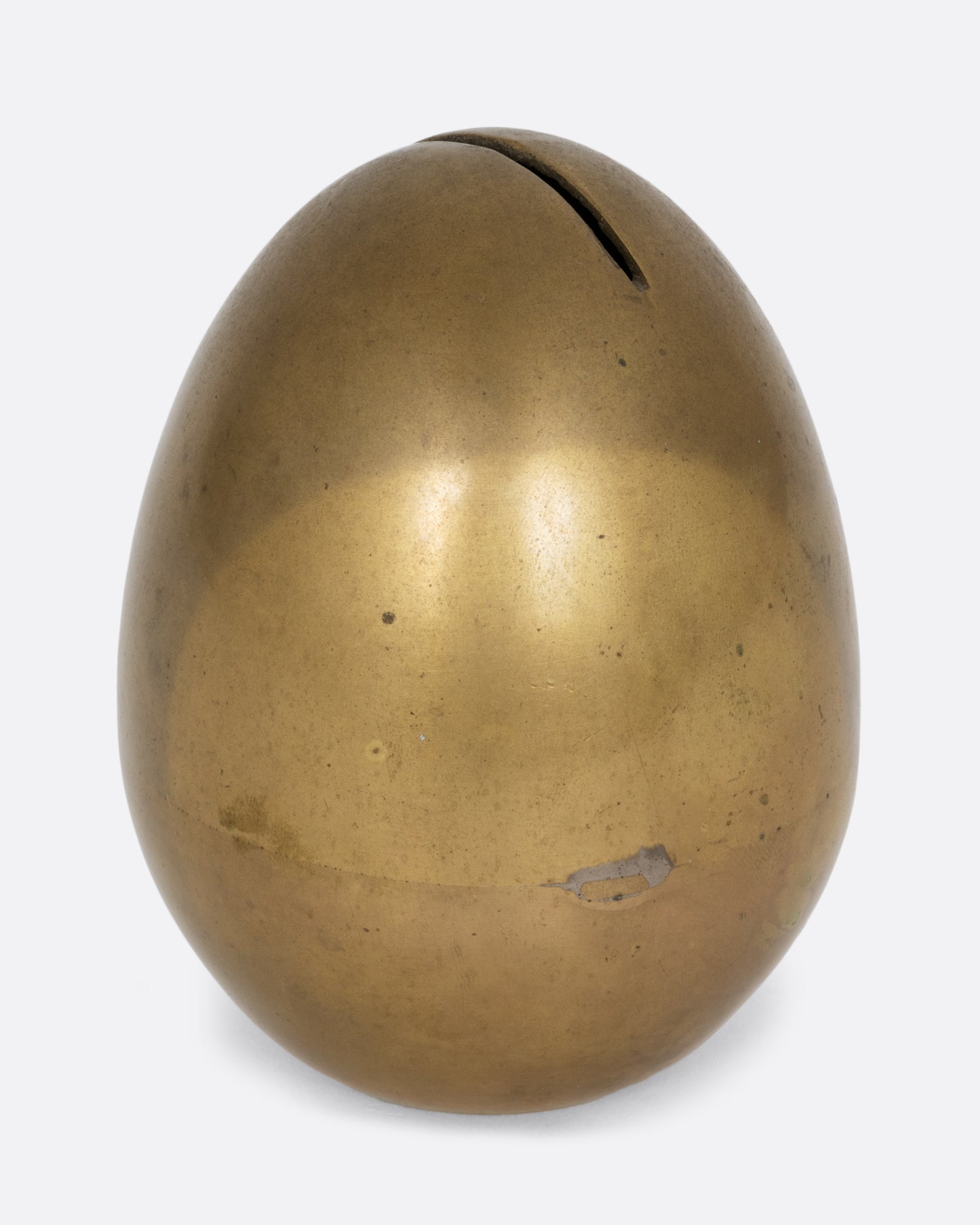 An egg shaped brass bank. Shown from the side.