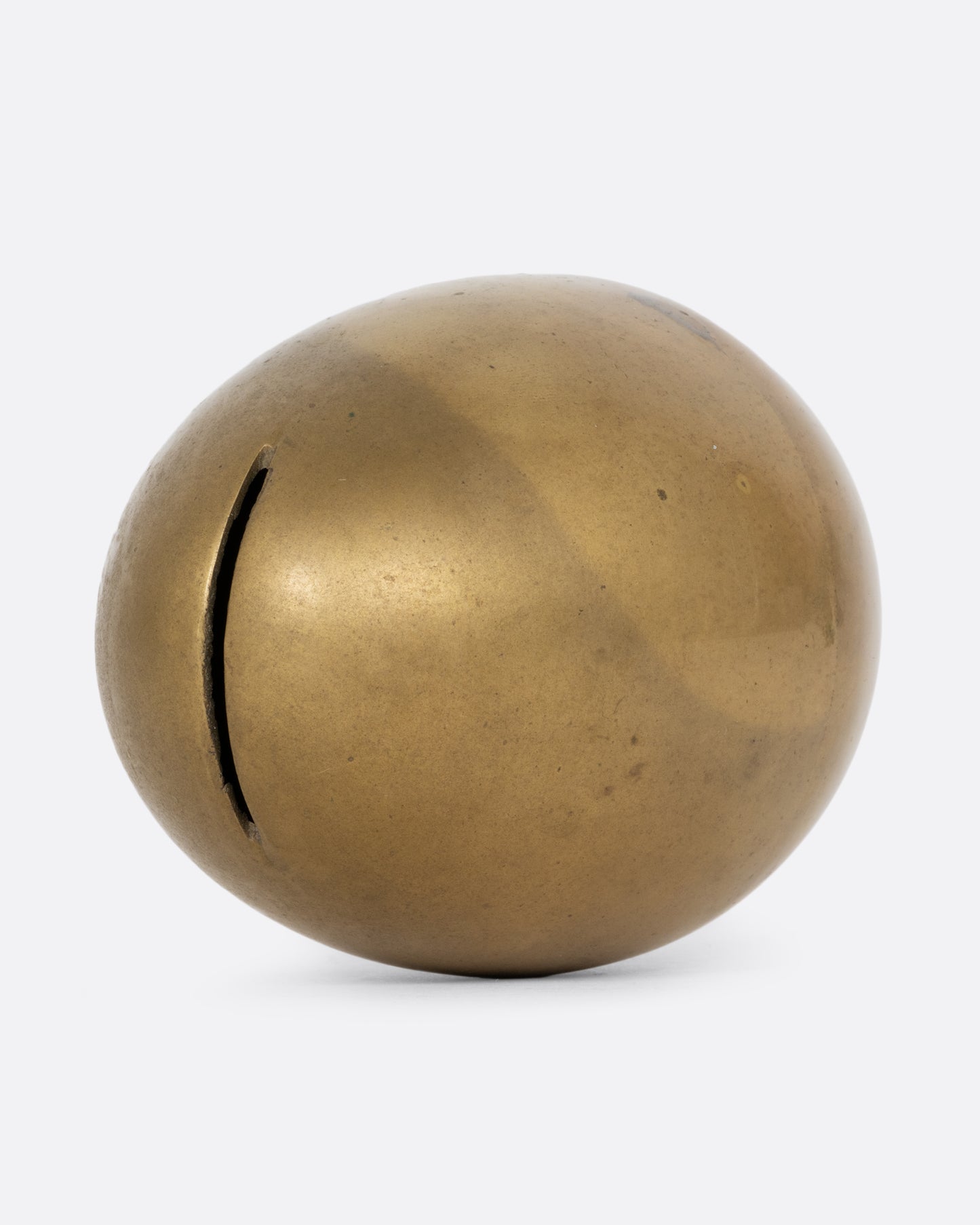An egg shaped brass bank. Shown on its side from the top.