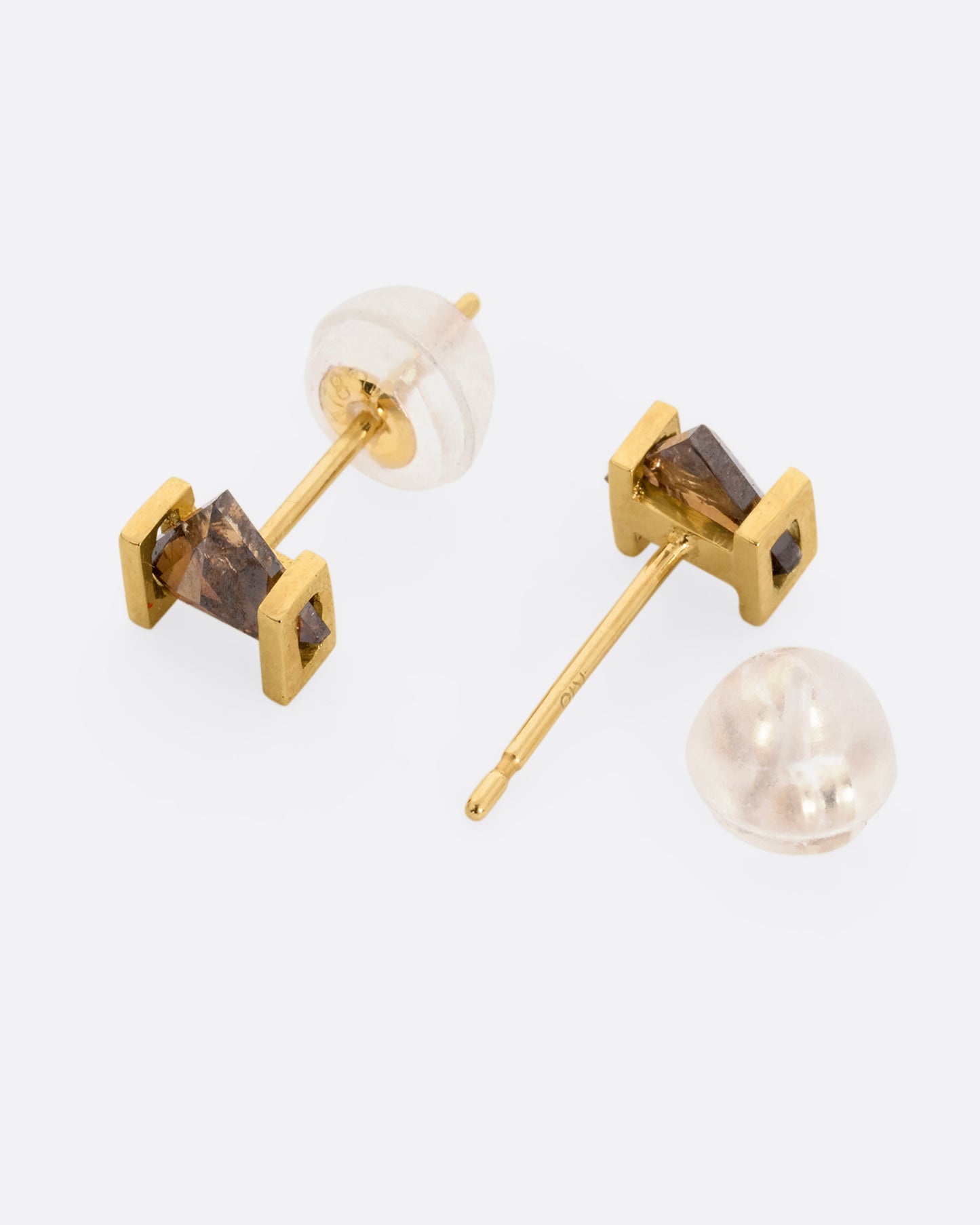 Yellow gold earrings with open rectangular settings and cognac diamonds. One earring is shown from the front lying flat. The other earring is shown from the back lying flat.