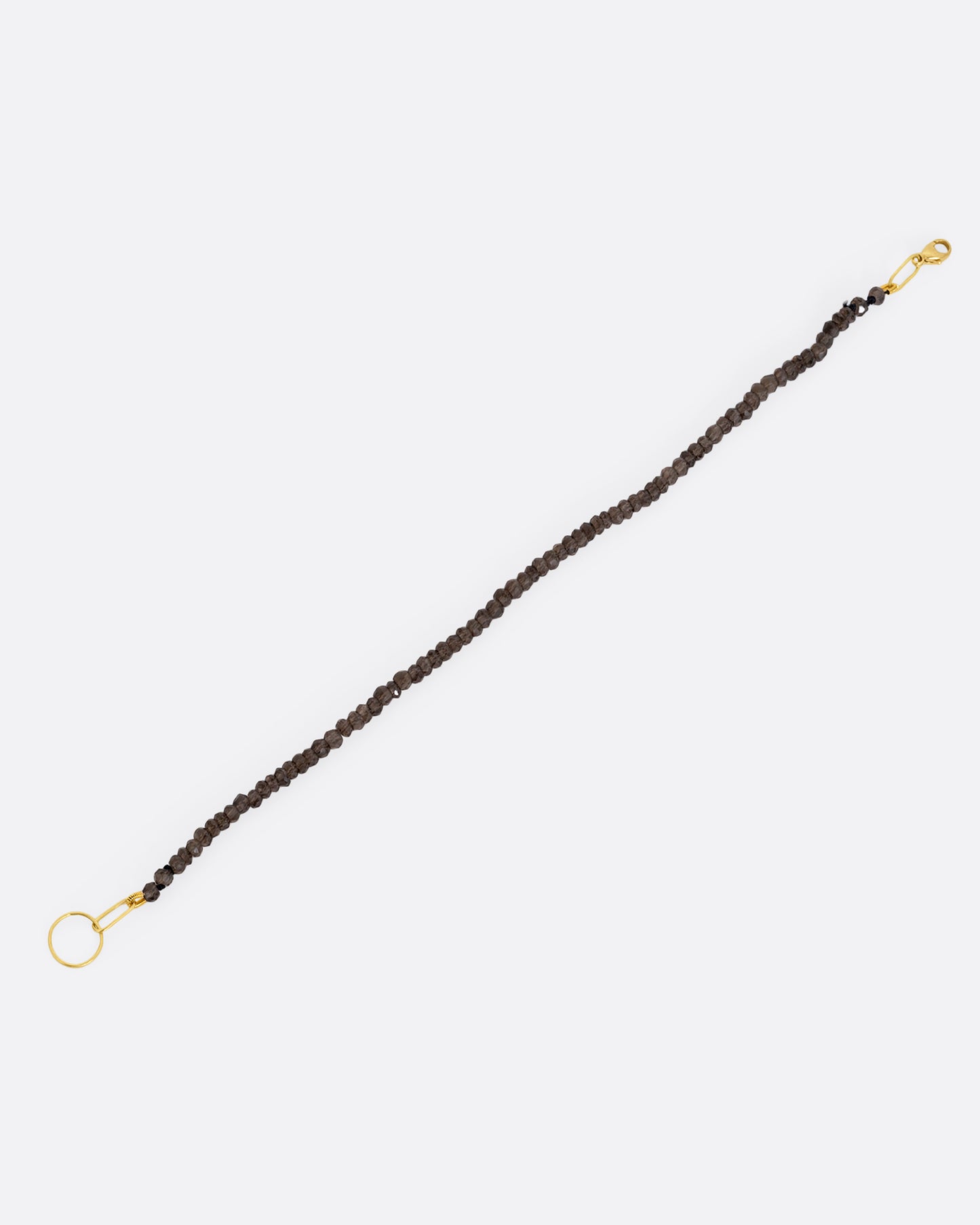 A beaded smoky quartz bracelet with a yellow gold clasp. Shown from the front.