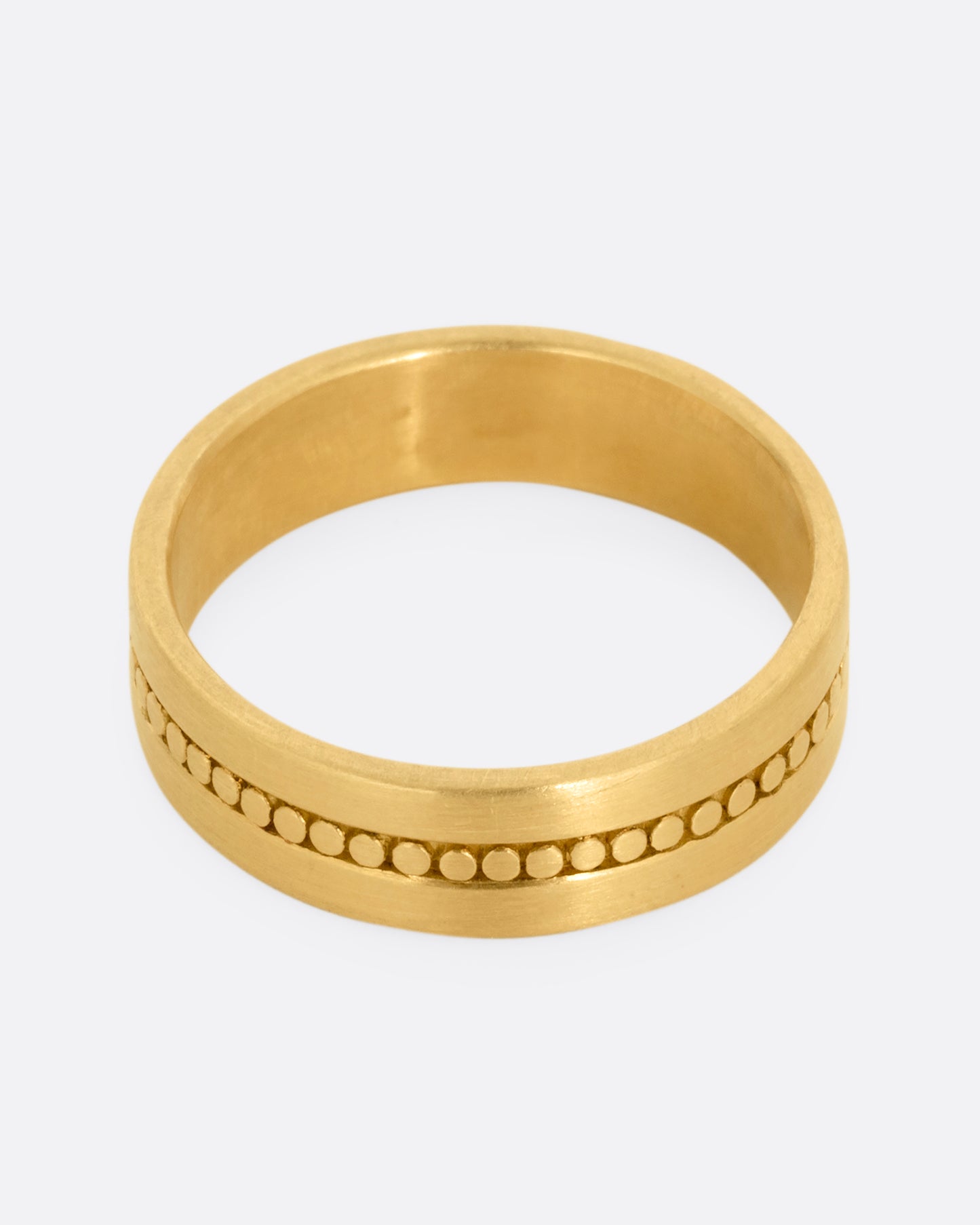 A yellow gold band with a center stripe of circles. Shown from the front.