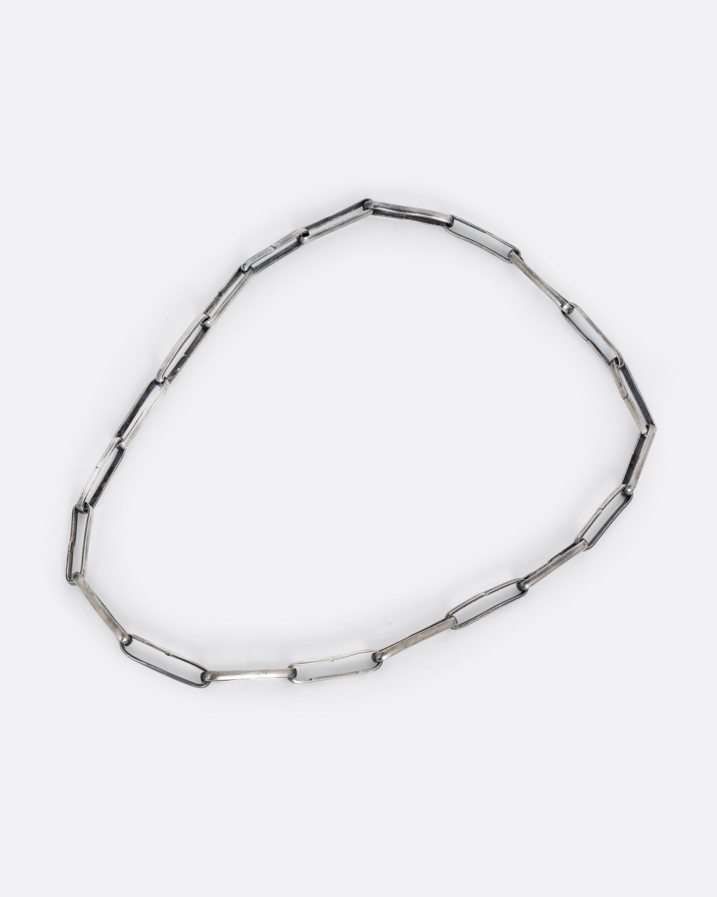 A silver wide link cable chain necklace. Shown from the front from a bird's eye view.