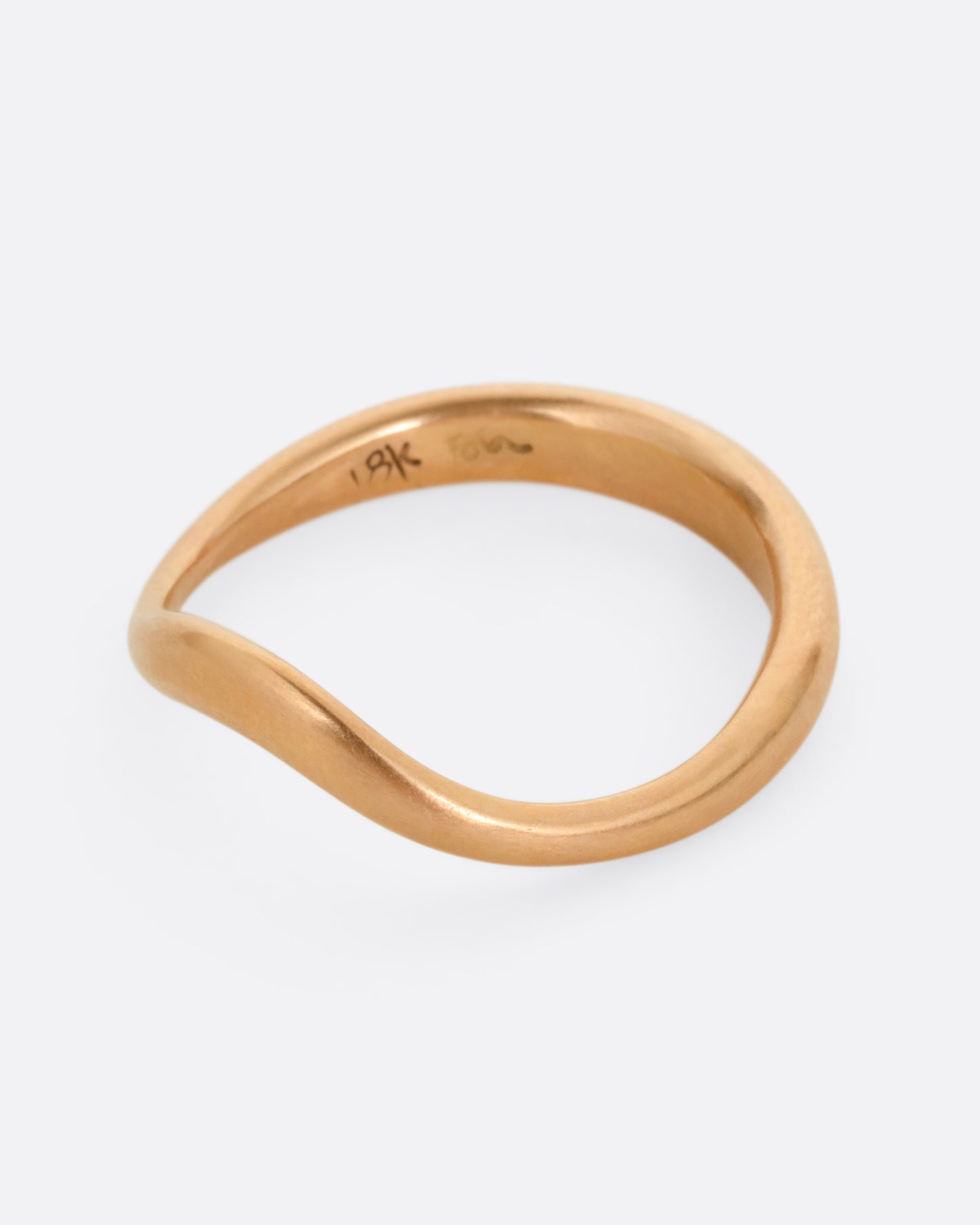 A rose gold ring with a gentle curve in the front. Shown from the front.
