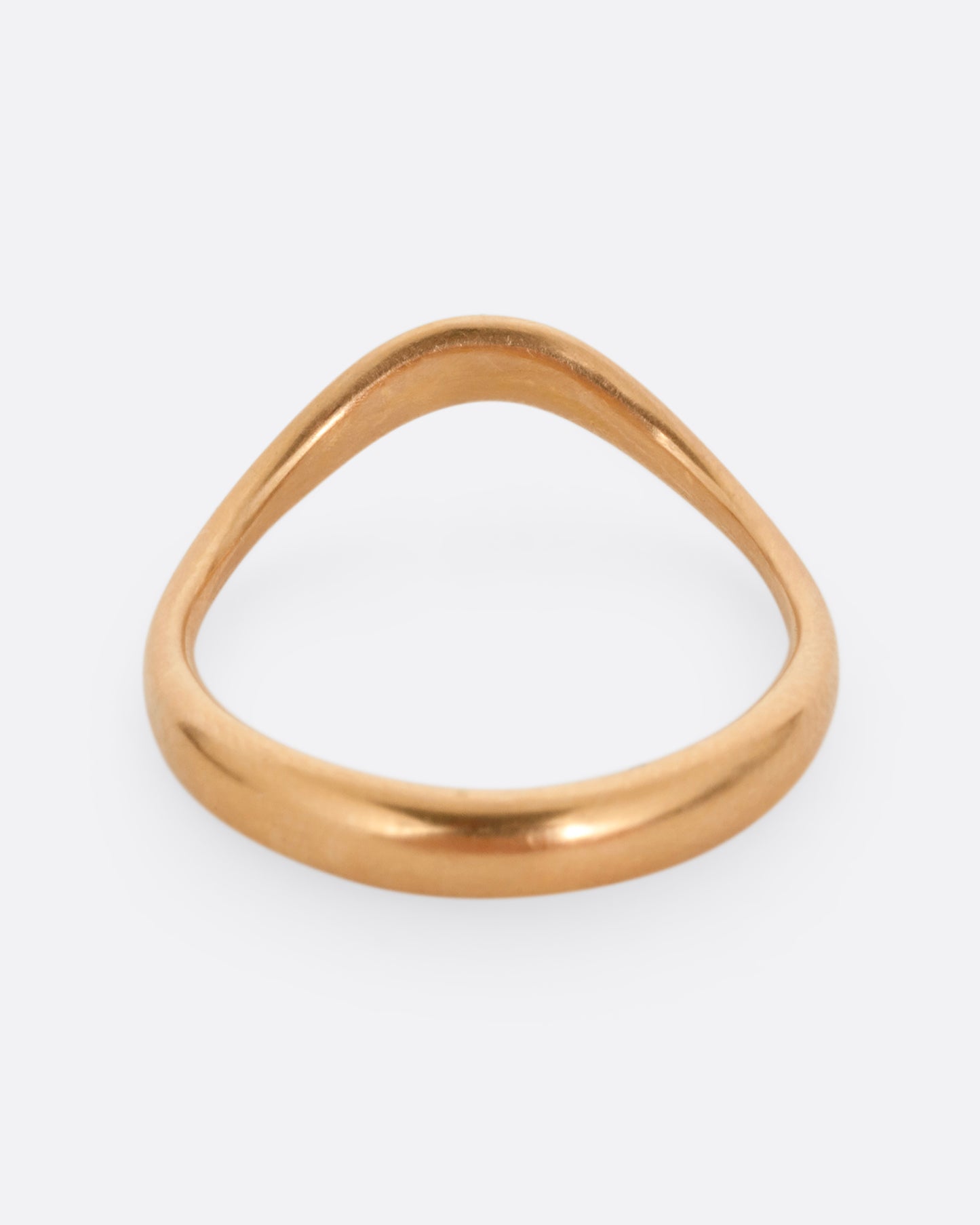 A rose gold ring with a gentle curve in the front. Shown from the back.