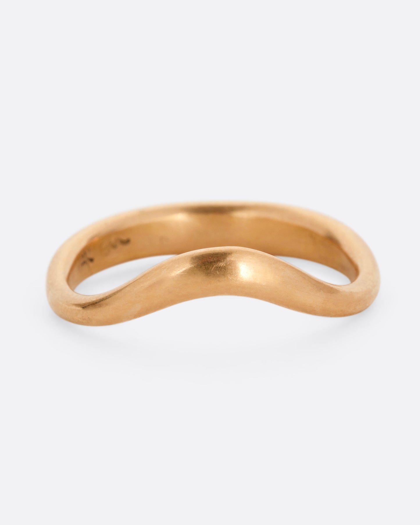 A rose gold ring with a gentle curve in the front. Shown from the front.