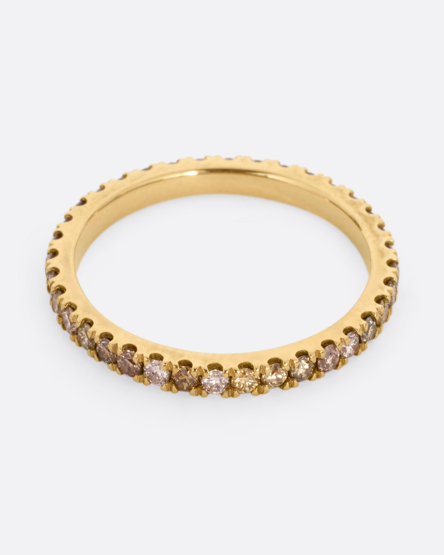 A yellow gold eternity band with olive, champagne, and cognac diamonds. Shown from the front.