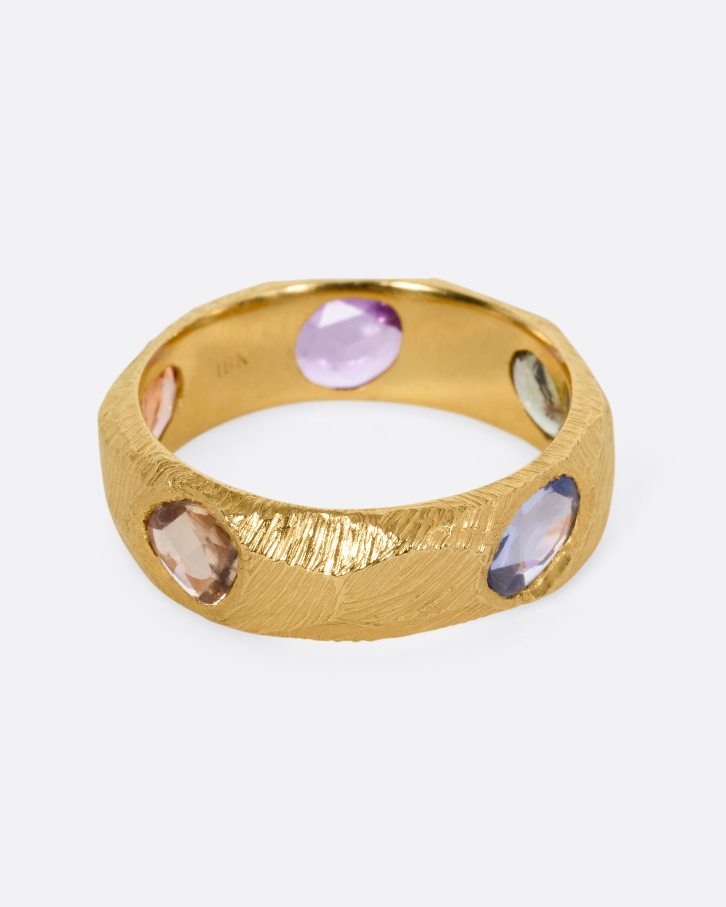 A yellow gold ring with multicolored rose cut sapphires, shown from the front.