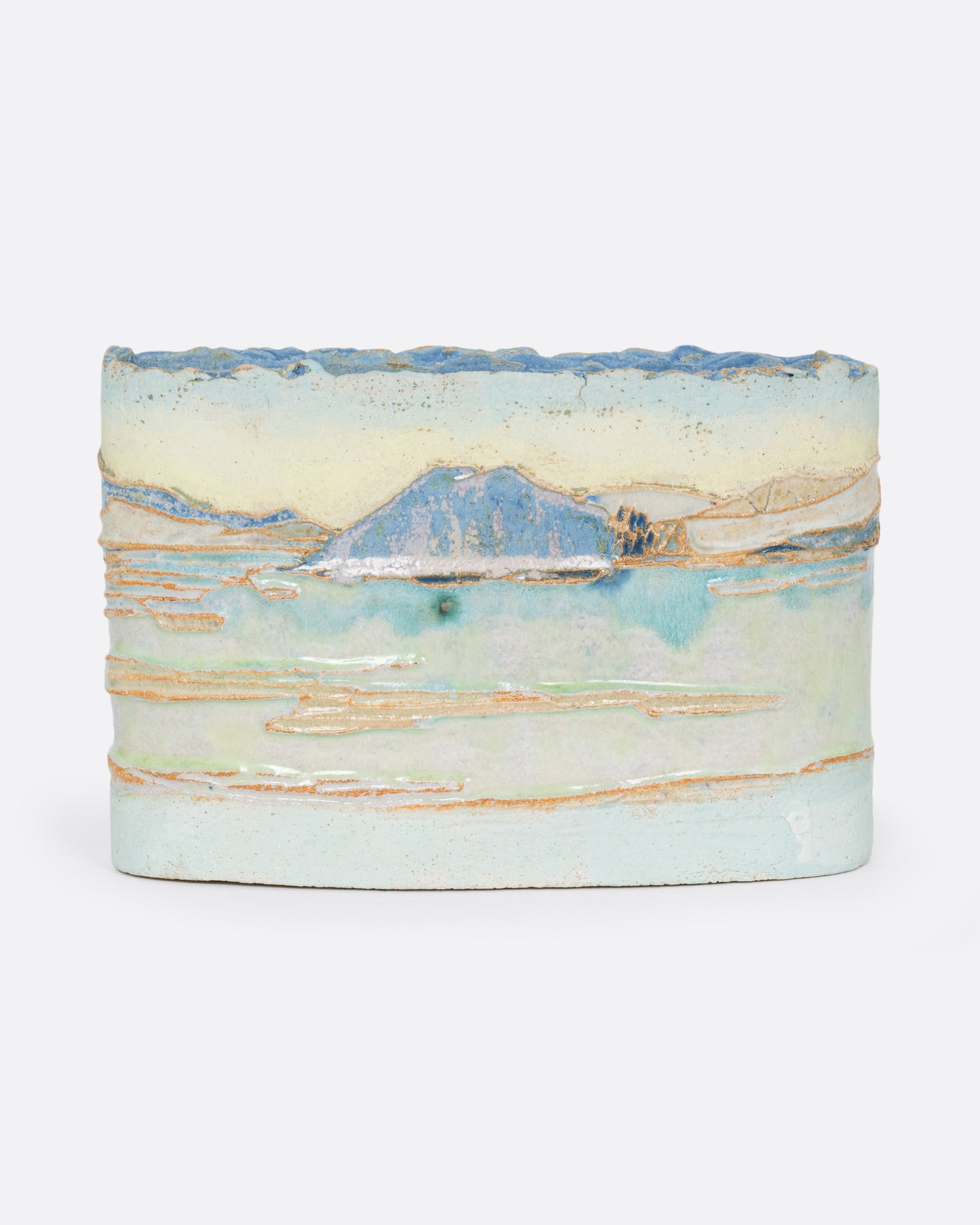 An oblong ceramic vessel with a landscape on it. Shown from the front.