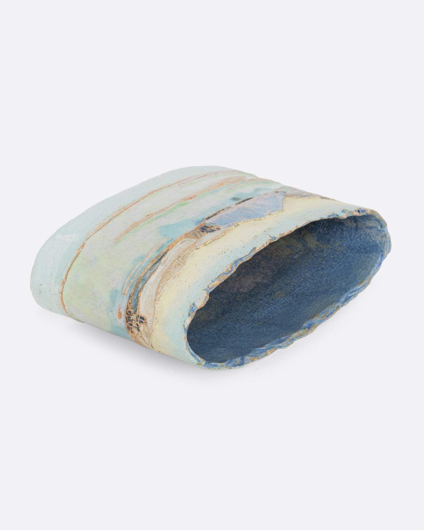An oblong ceramic vessel with a landscape on it. Shown lying on its side from the top.