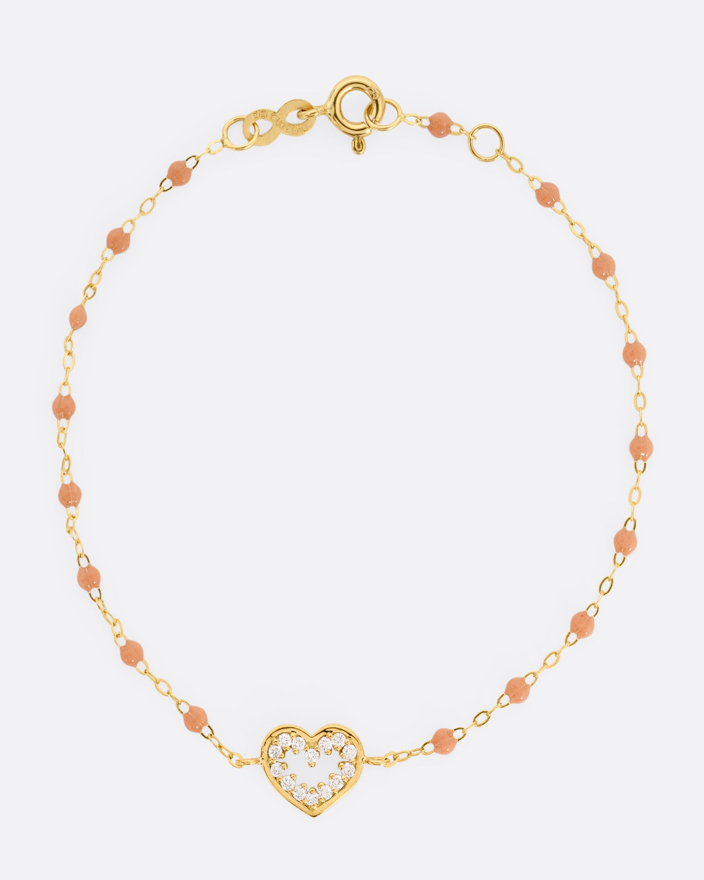 A yellow gold cable chain bracelet with a diamond lined heart charm and caramel brown resin droplets throughout. Shown from the front.