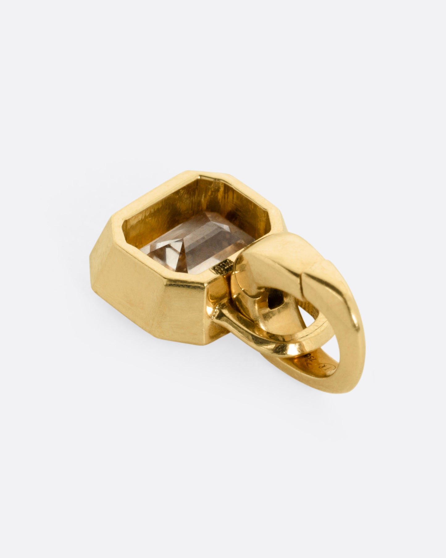A yellow gold charm with a step cut champagne diamond, shown from the back.