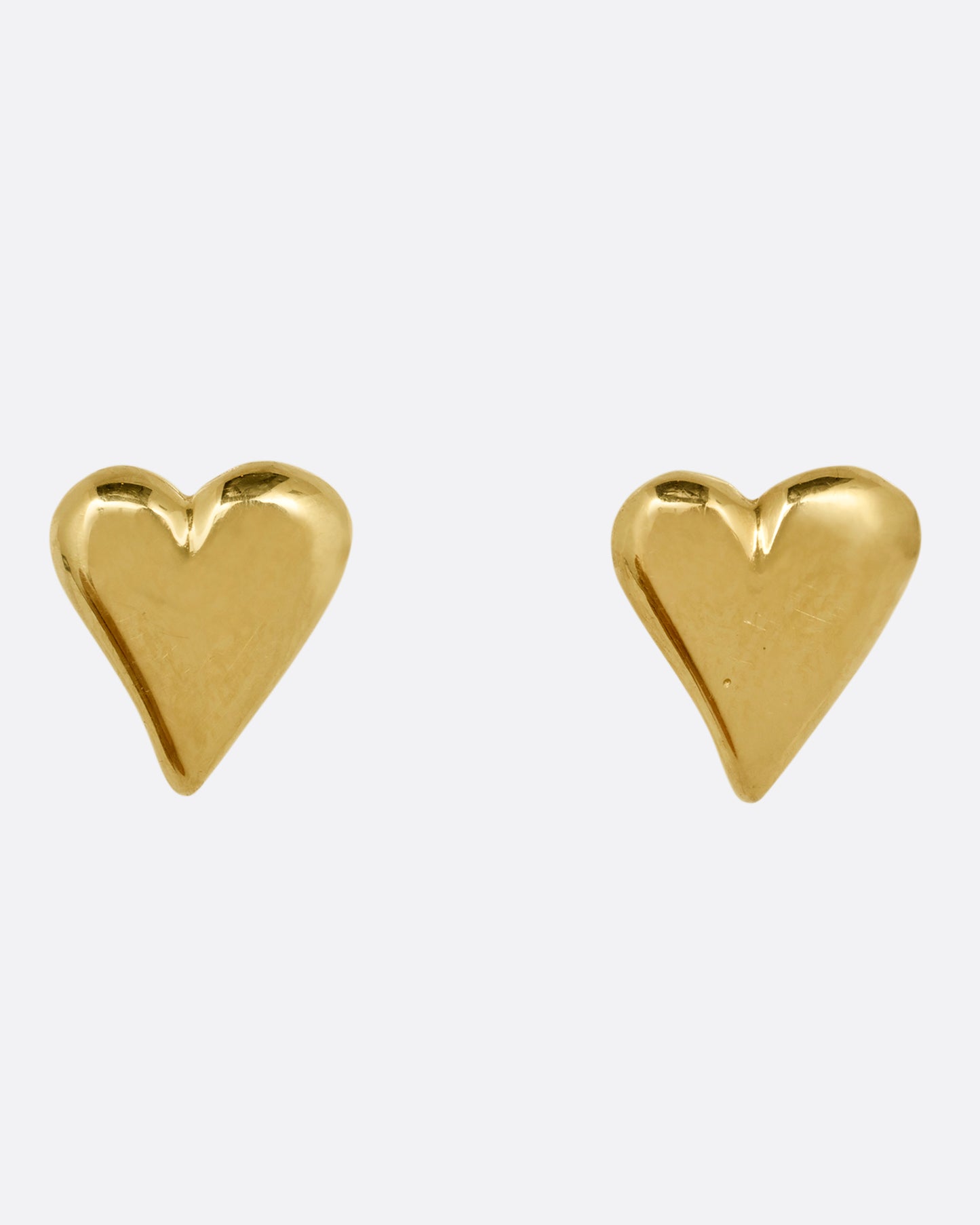 A pair of yellow gold heart earrings. Shown from the front.