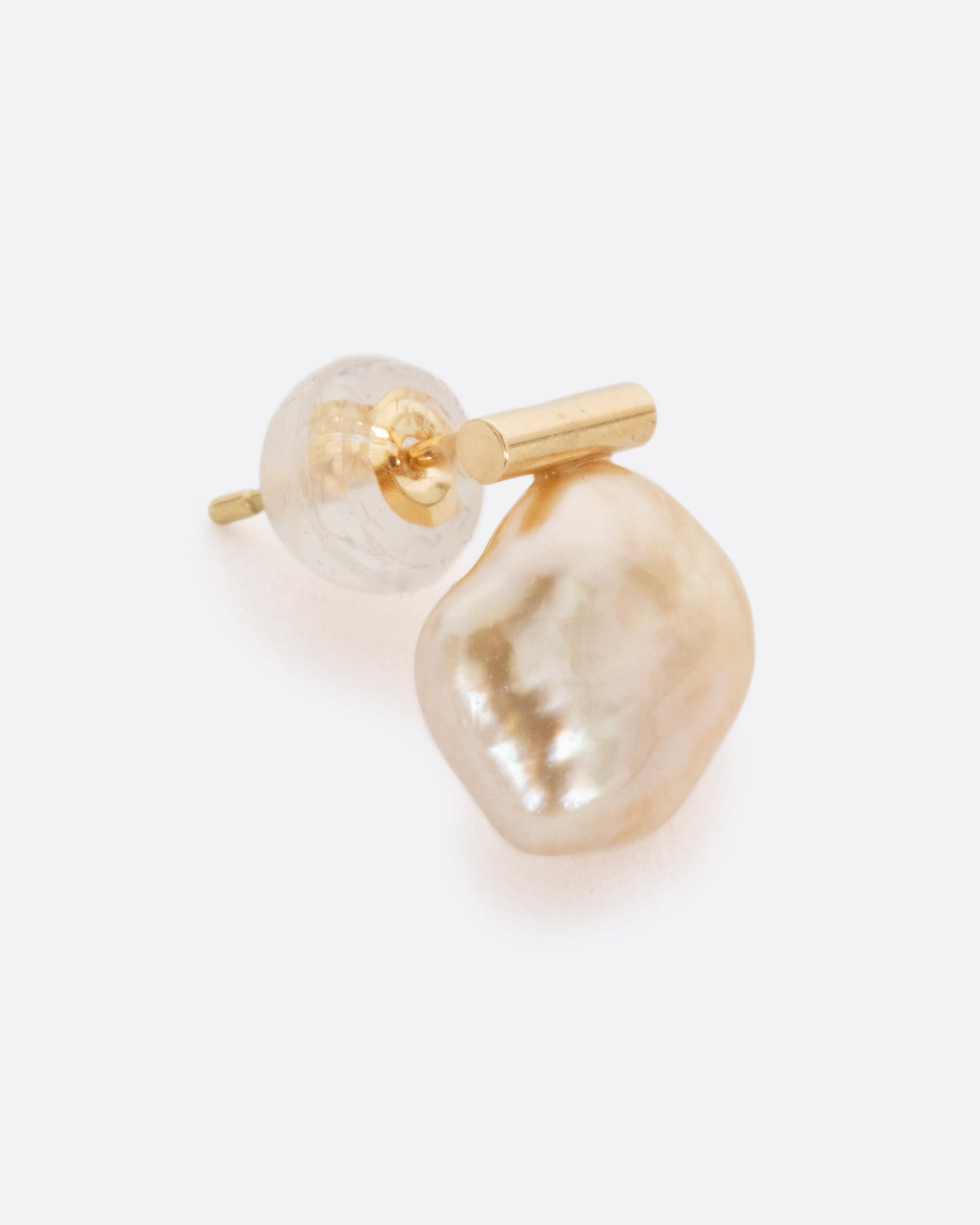 A pearl pendant suspended from a gold bar setting. Shown from the side.