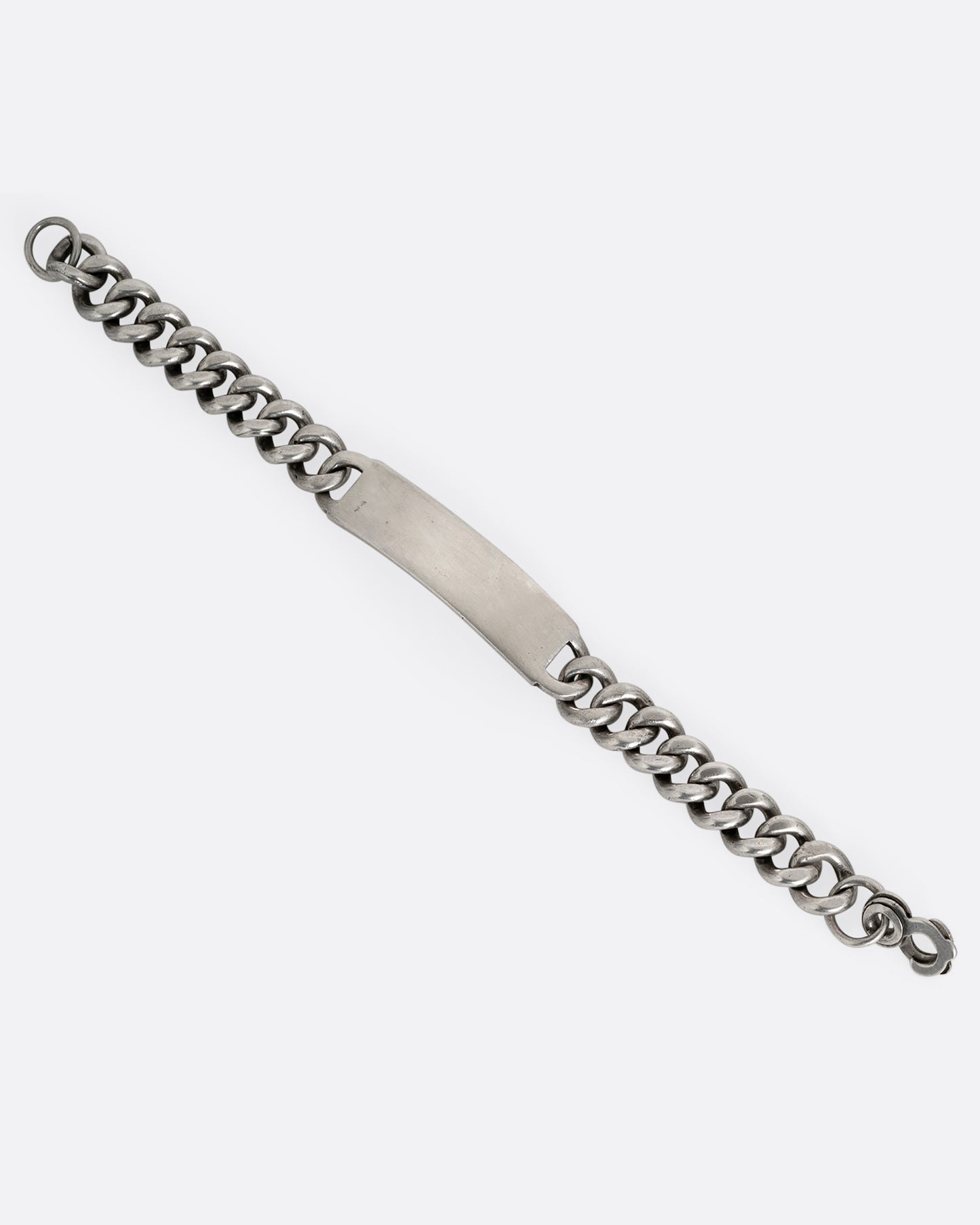 A silver curb chain ID bracelet, shown from the front open.