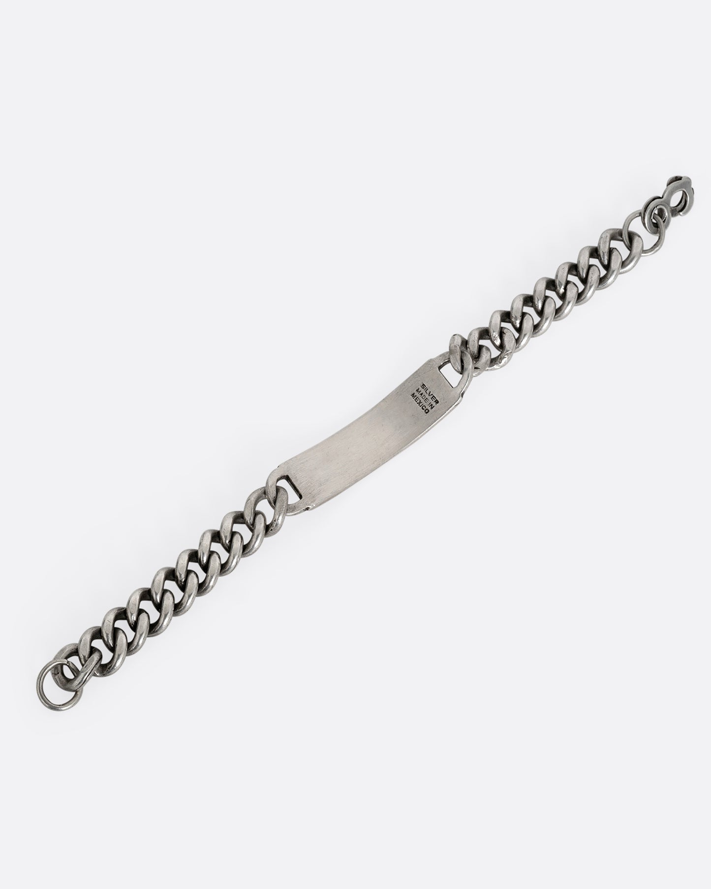 A silver curb chain ID bracelet, shown from the back open.