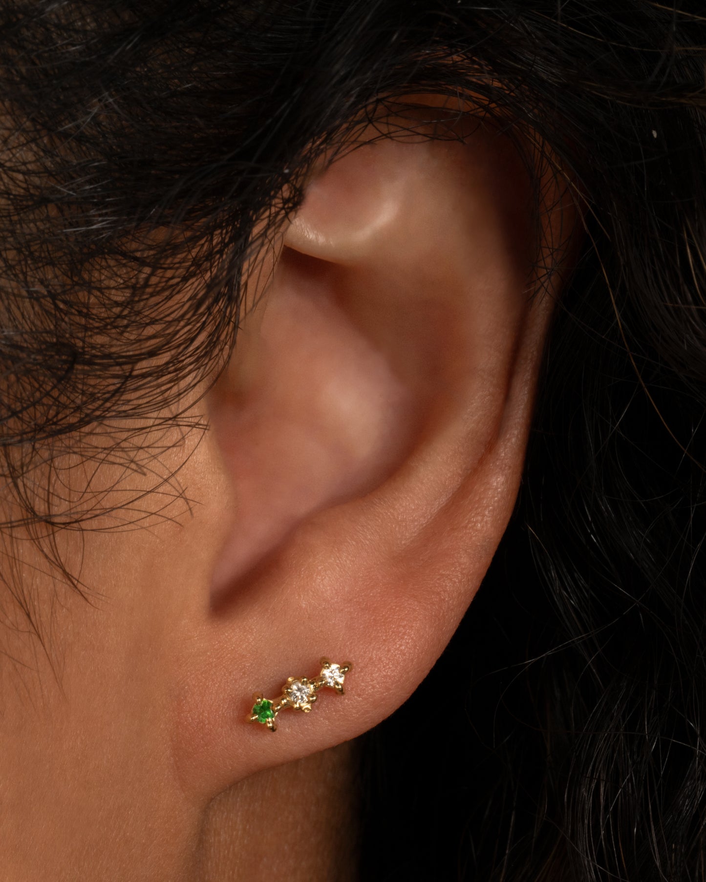 An ombré bar stud with three stones set in Ruta Reifen's signature textured prong settings.