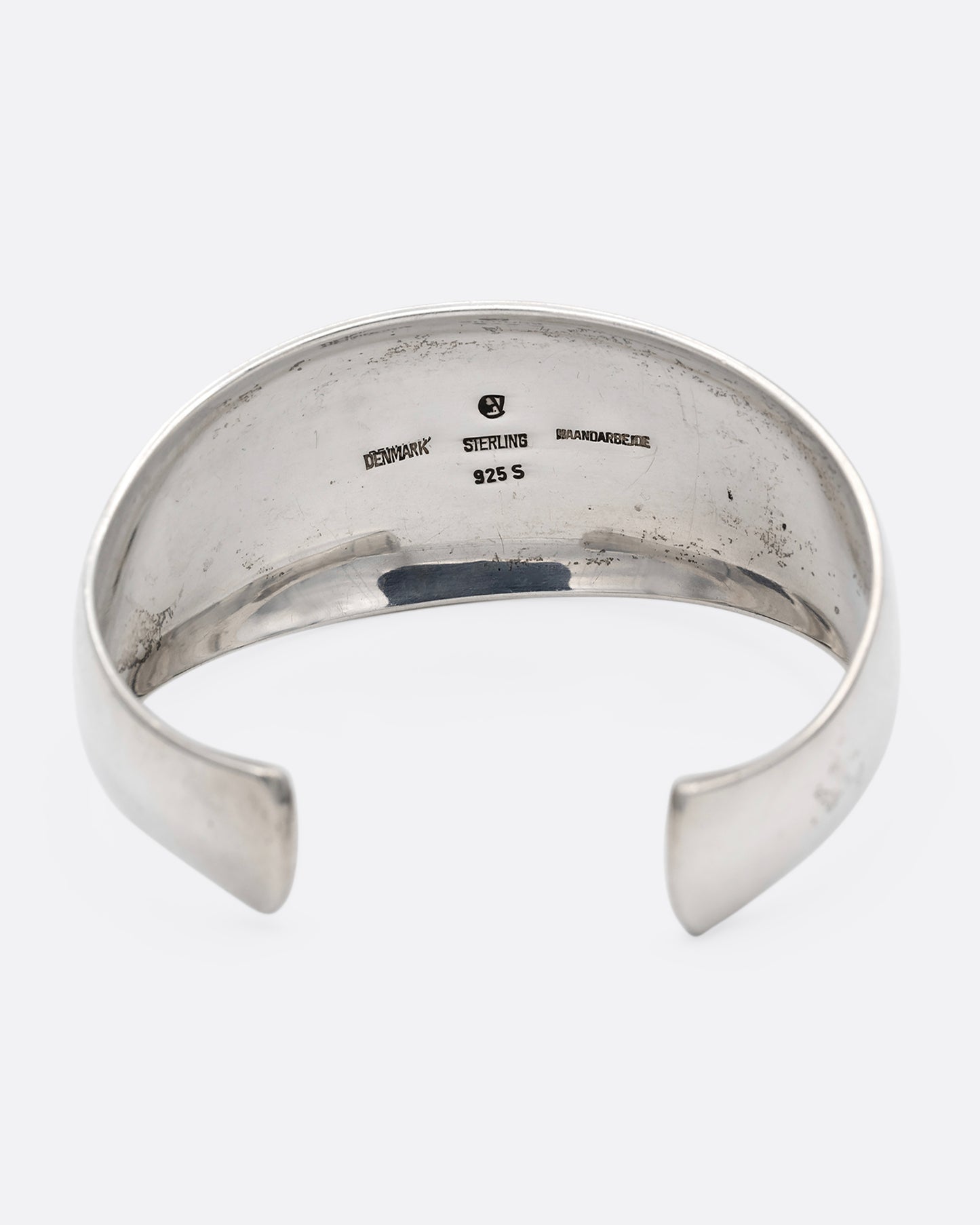 A silver cuff bracelet with smooth edges, shown from the back.