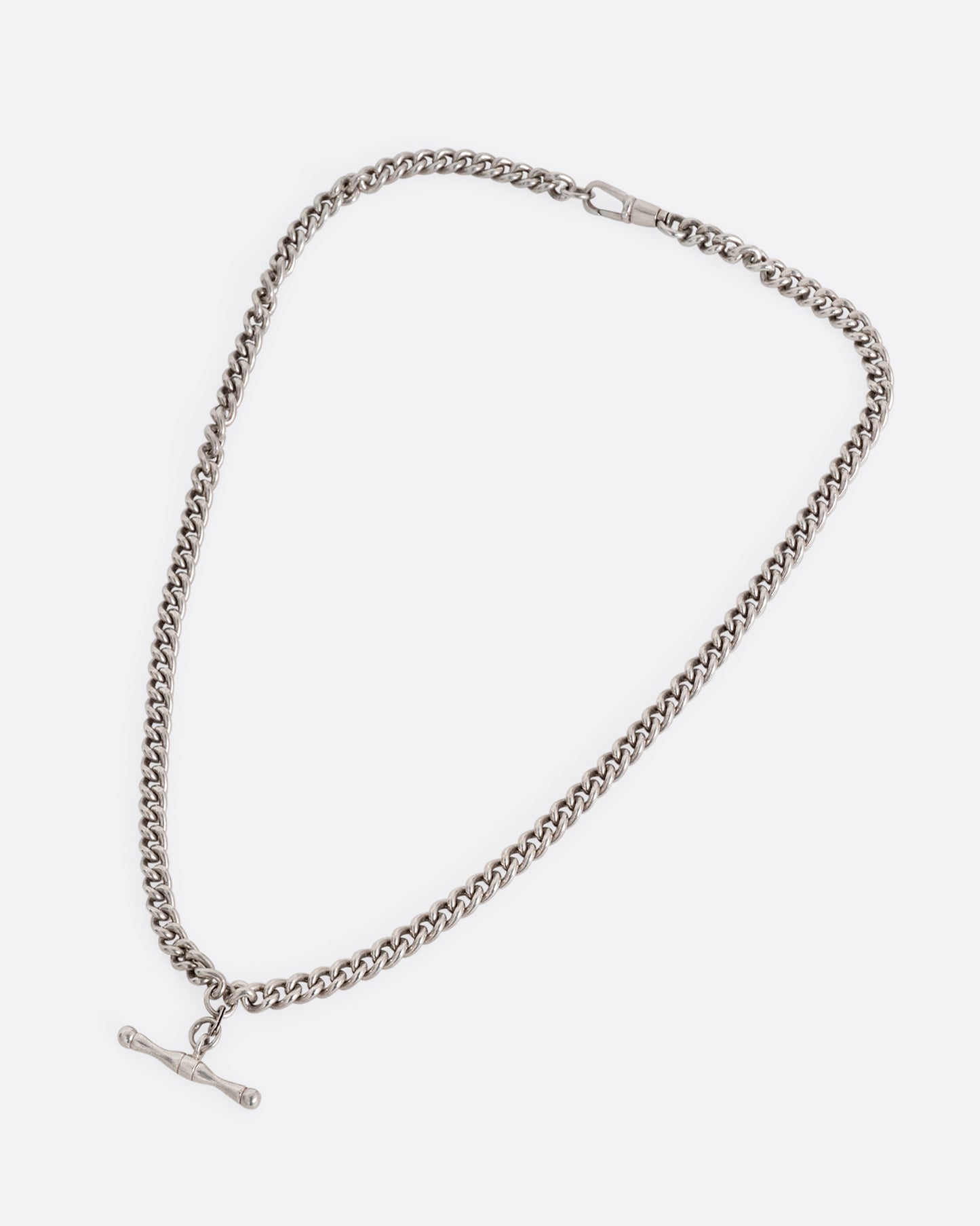 A silver curb chain pocket watch curb chain necklace with a T-bar on one end. Shown from the front.