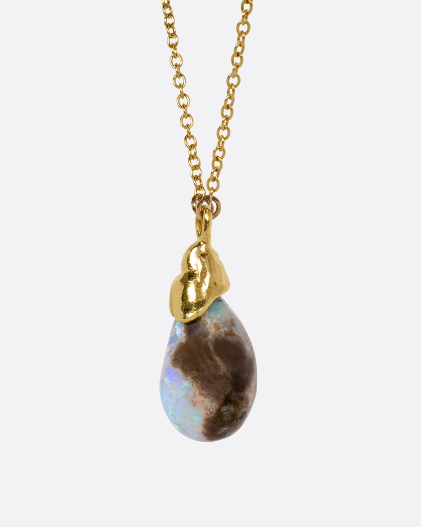 A yellow gold necklace with a teardrop shaped opal pendant, shown from the back.
