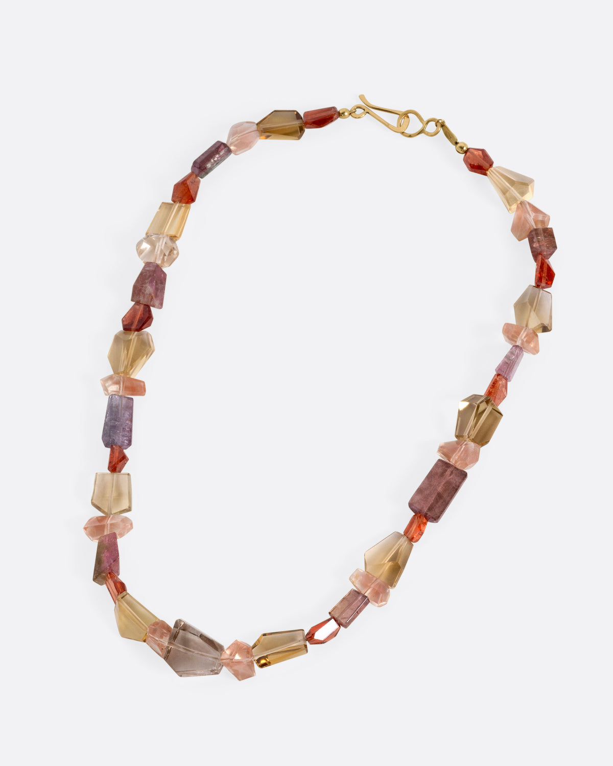 A beaded necklace of freeform tourmalines, hessonite garnets, Oregon sunstones, and citrines, shown from the front.