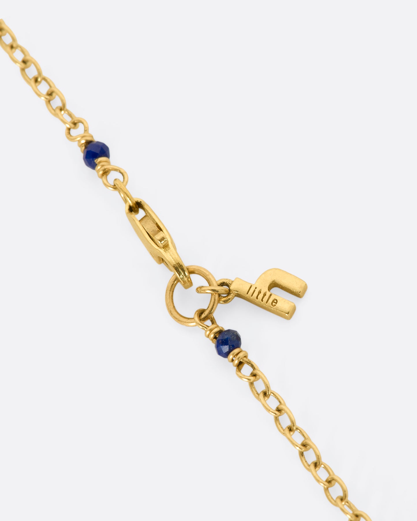 A yellow gold necklace with a hollowed out pearl pendant filled with lapis and 22k gold beads. Shown close up of the clasp.