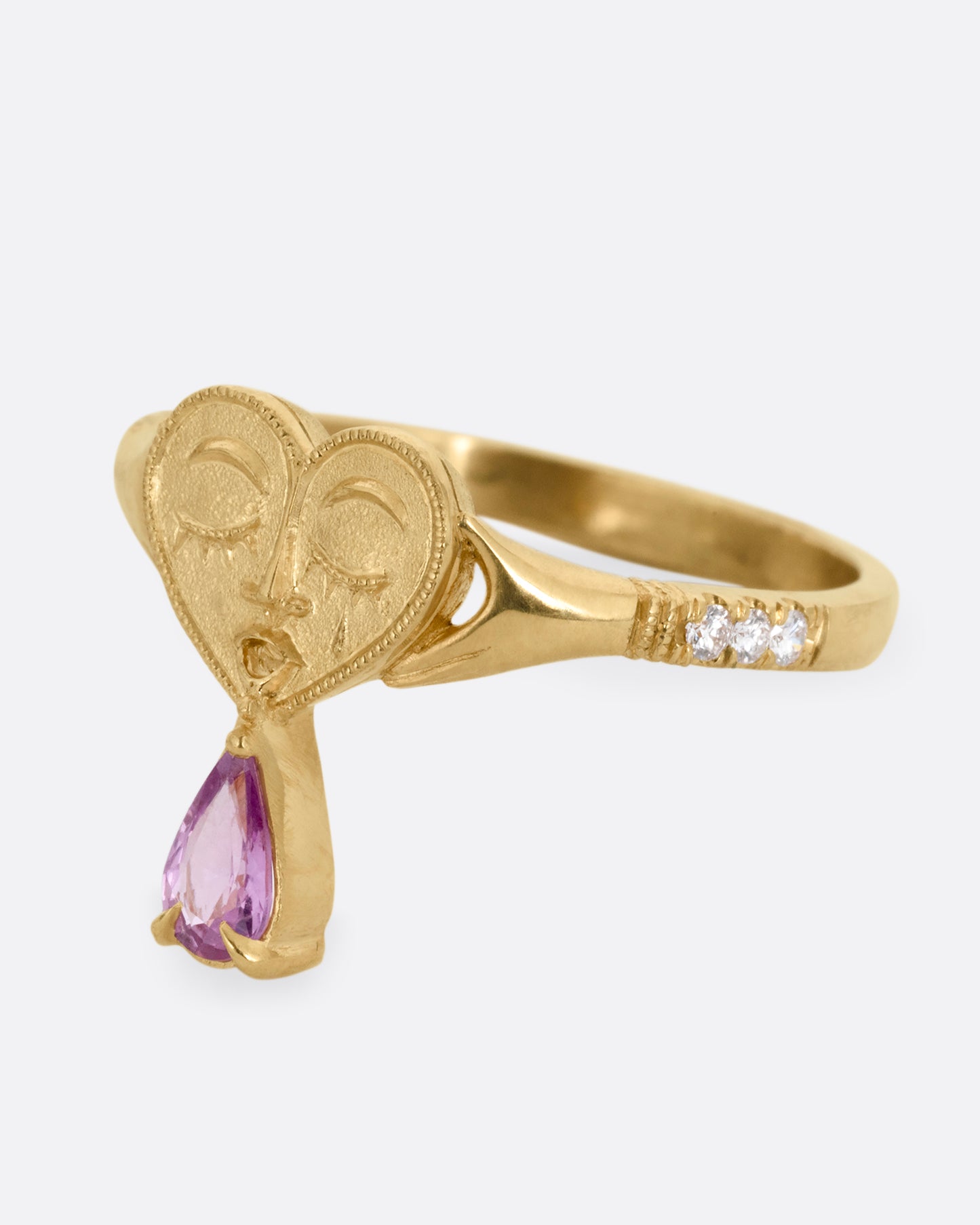 A yellow gold ring with a triangular face, white diamond accents, and cutouts. Shown from the side.