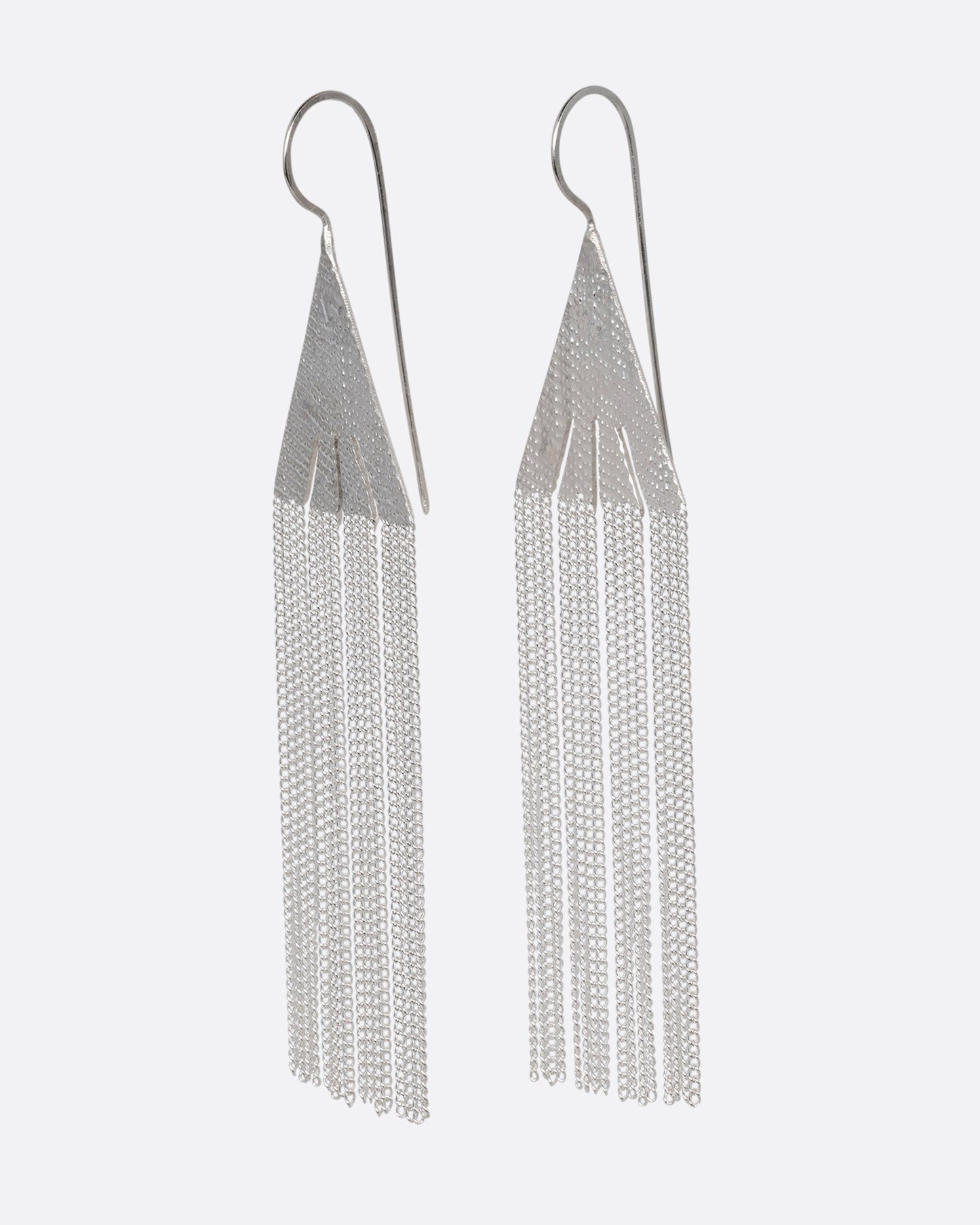 A pair of silver fringe earrings with triangular tops. Shown from the side.