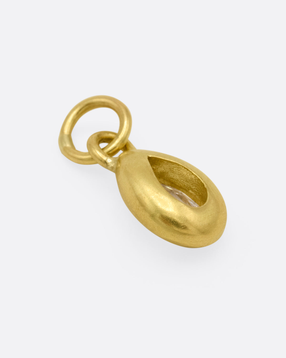 A yellow gold pear shaped and rose cut diamond charm shown from the back.