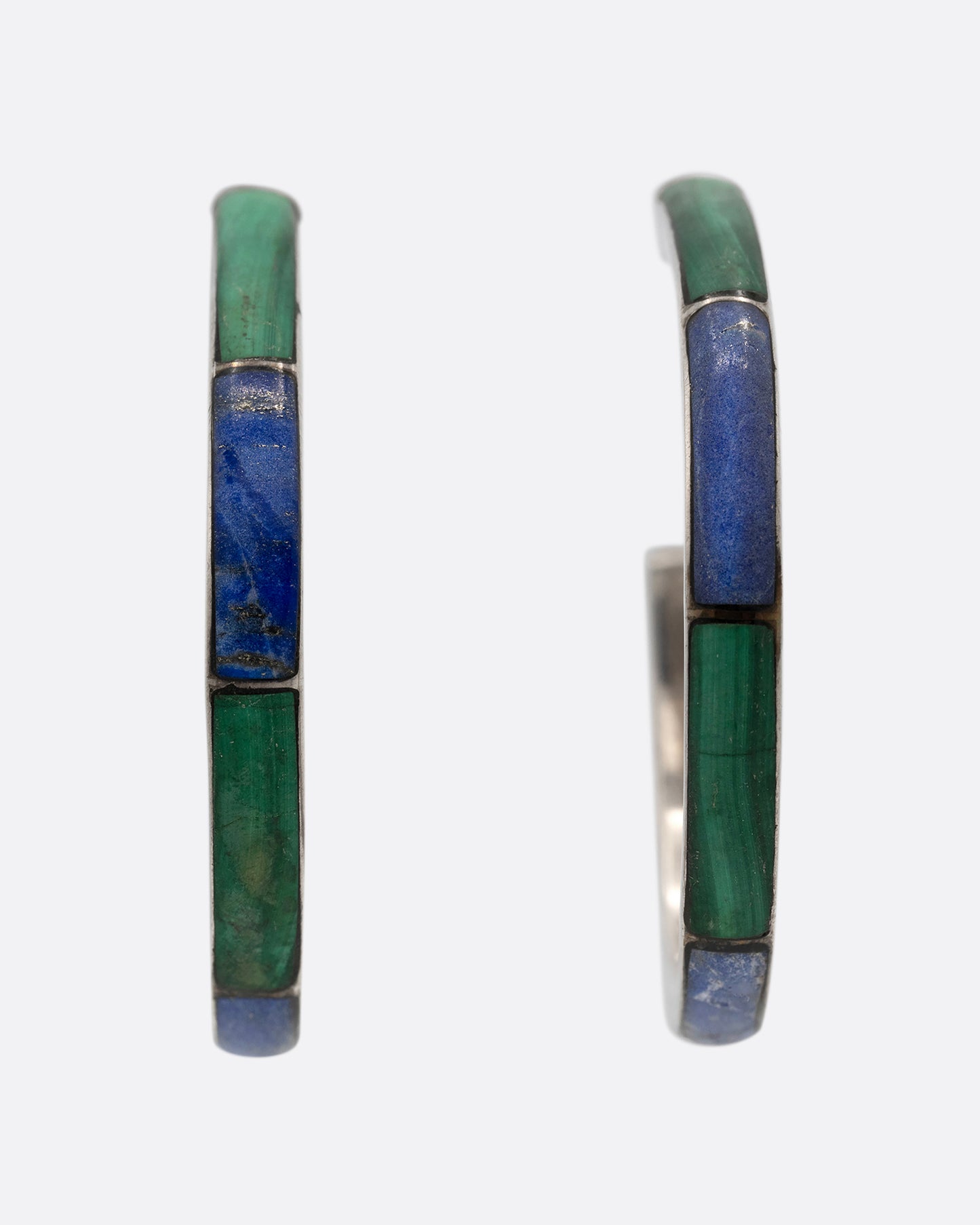 A pair of silver hoop earrings with malachite and lapis inlay. Shown from the front.