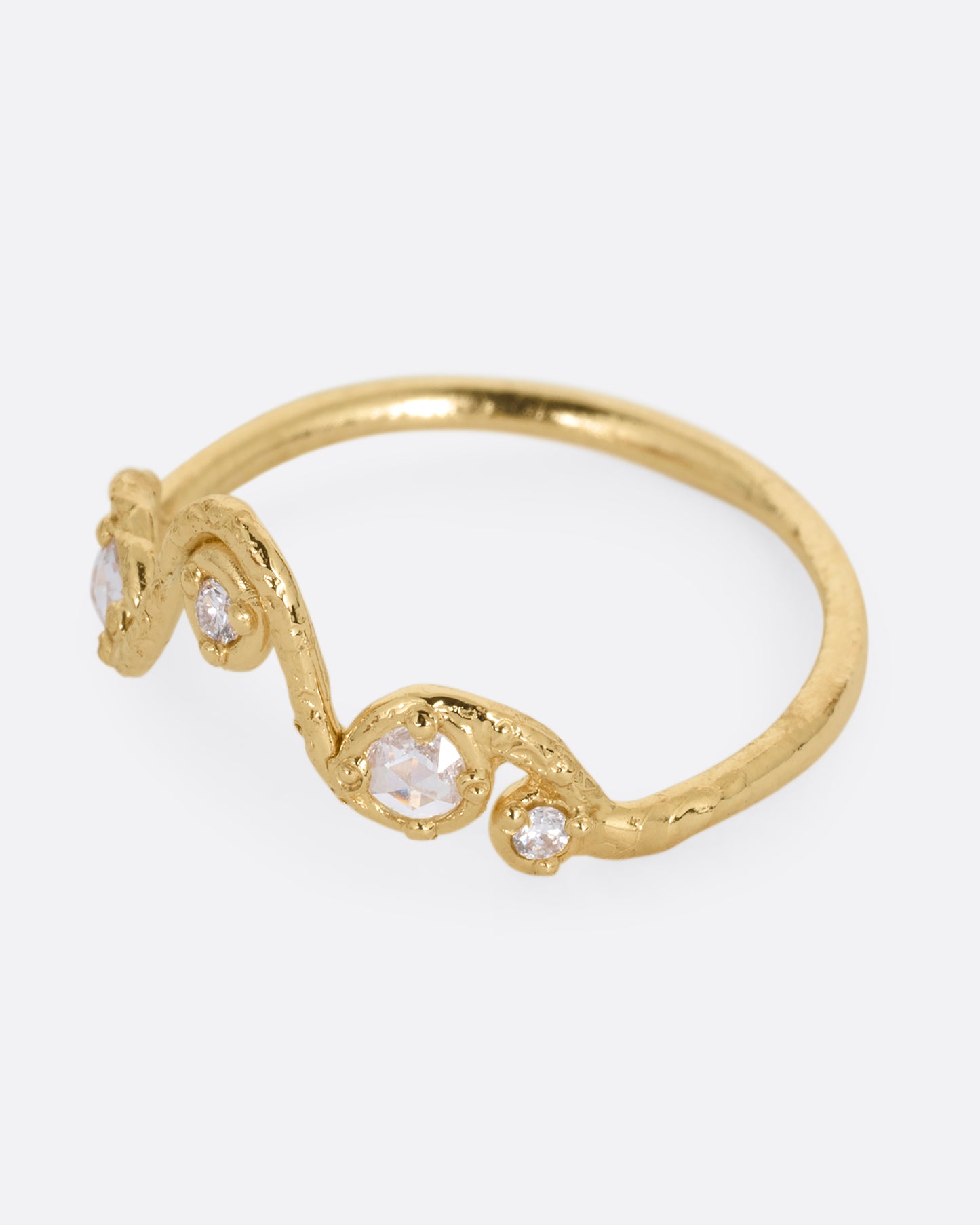 A wavy yellow gold ring with five round diamonds. Shown from the side.