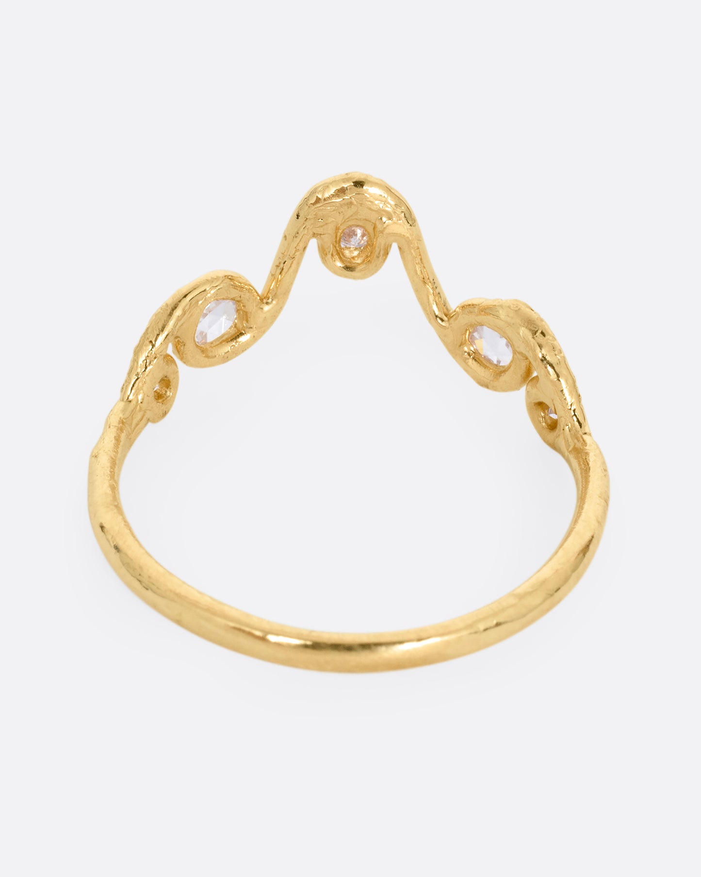 A wavy yellow gold ring with five round diamonds. Shown from the back.