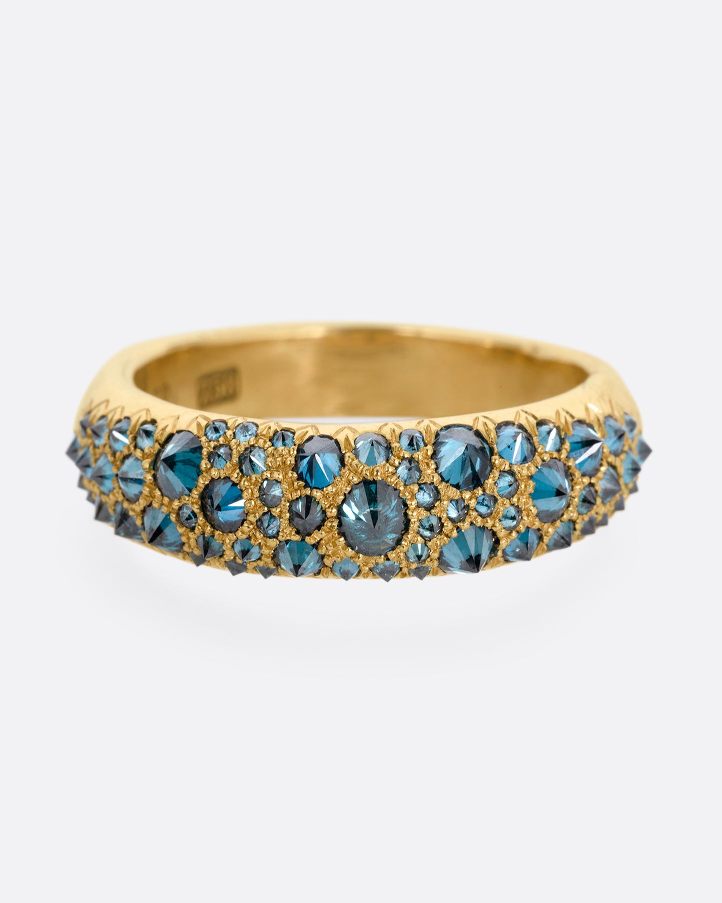 A yellow gold ring with reverse set blue diamonds, shown from the front.