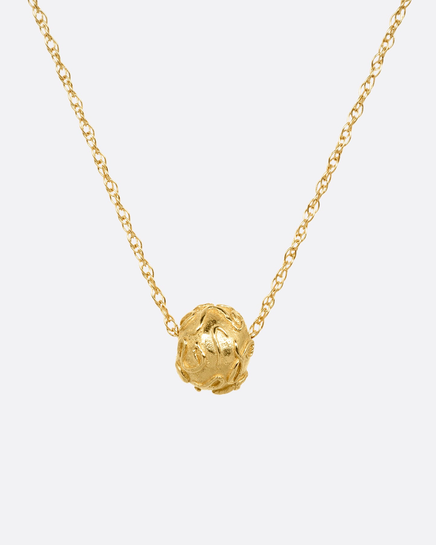 A yellow gold cable chain with a textured gold bead, shown from the front.