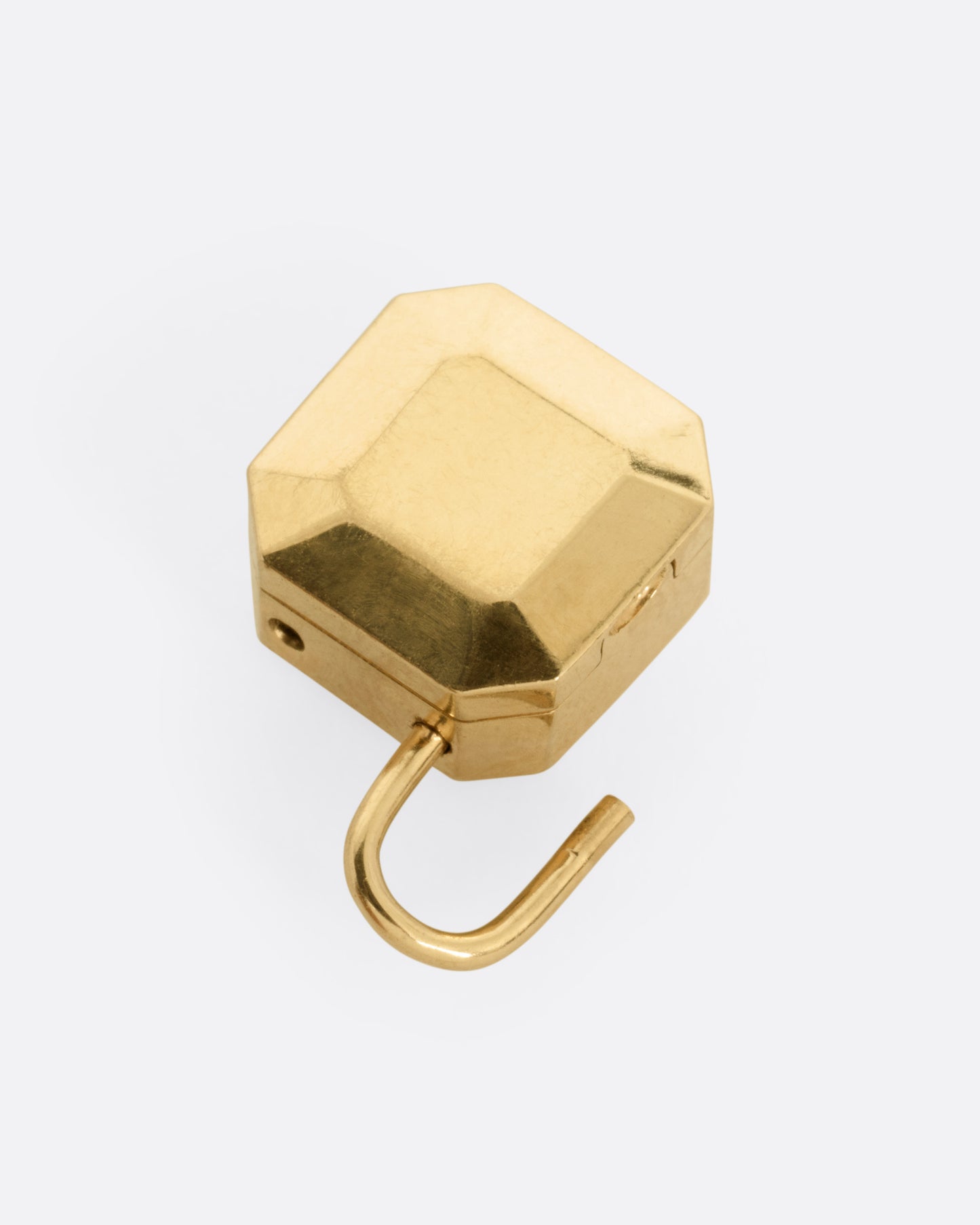 A yellow gold padlocket pendant featuring a large, faceted green emerald, shown from the back open.