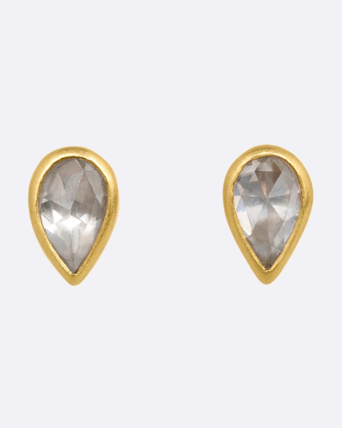 A pair of yellow gold tear drop shaped stud earrings with diamonds. Shown from the front.