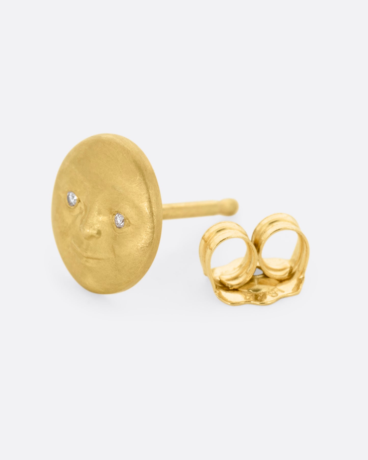 A yellow gold moon face stud earring with diamond eyes. Shown from the side open.