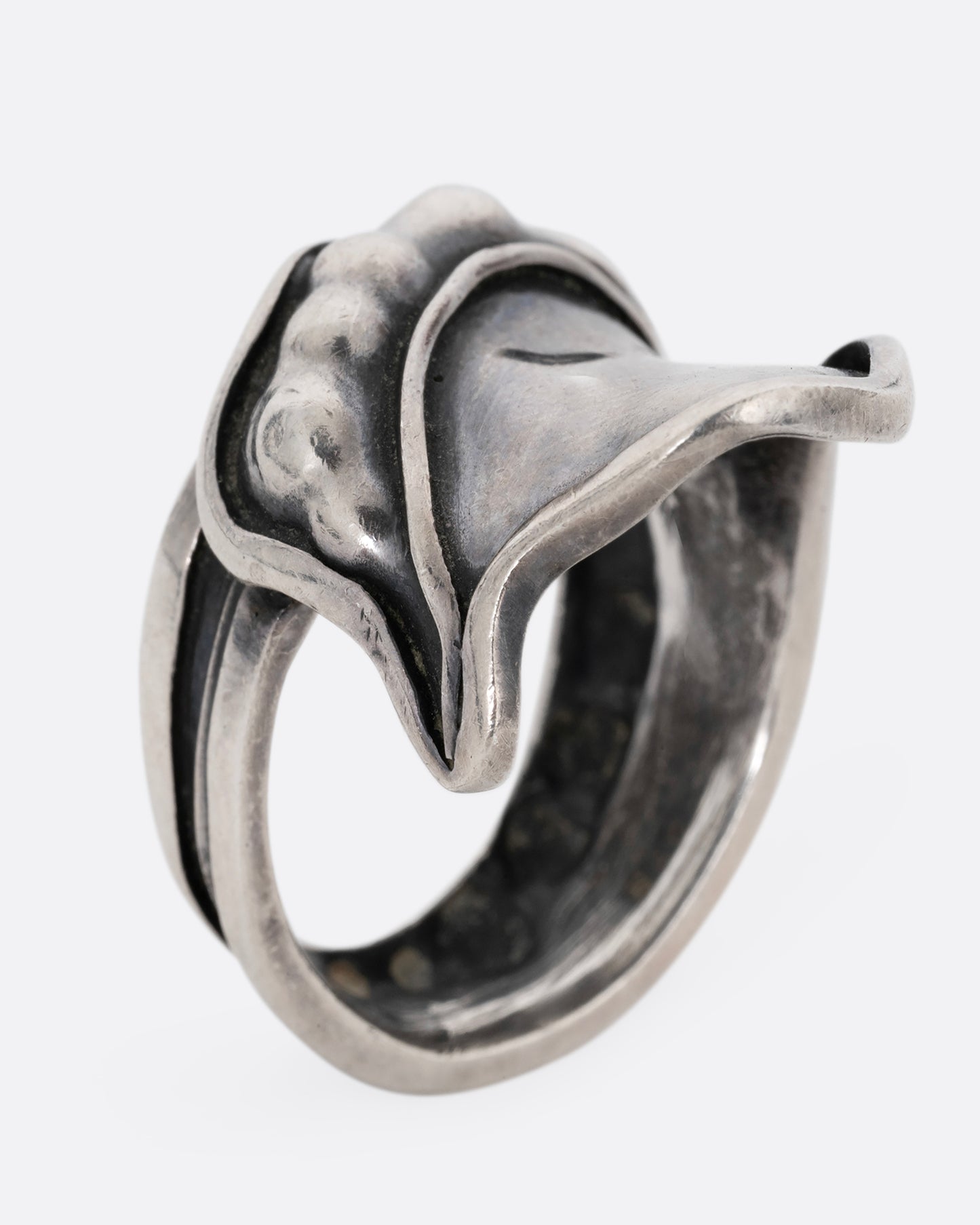 A silver leaf shaped wrap ring with silver drops along the top edge. Shown standing up from the side.